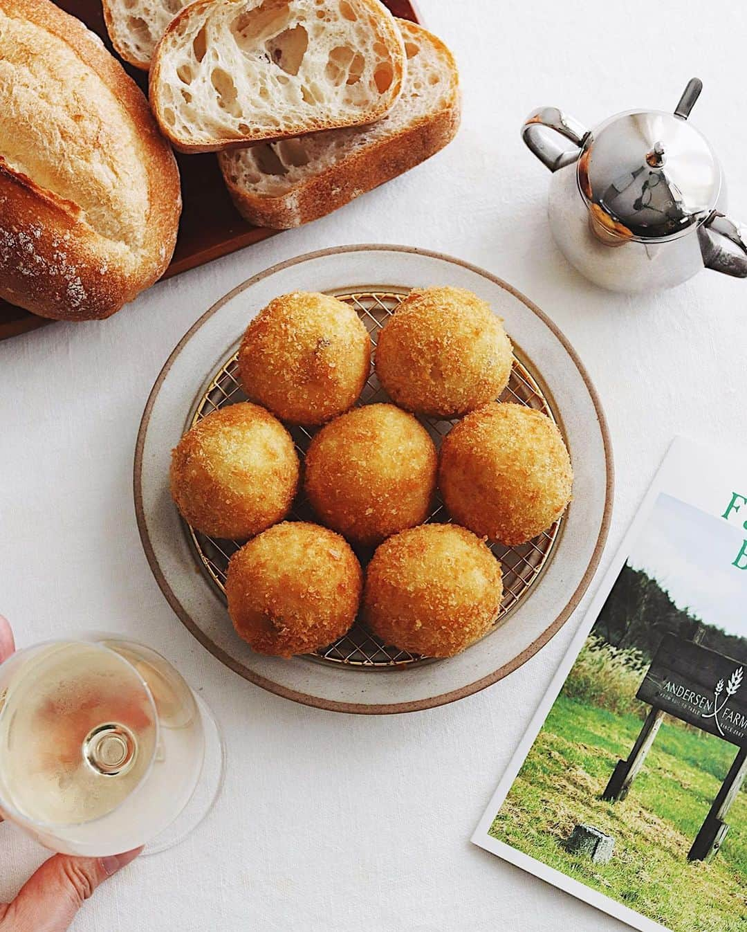 樋口正樹さんのインスタグラム写真 - (樋口正樹Instagram)「croquette & bread . 今夜はコロッケおかずに パンとワインを楽しむ会、 ＆祝カープの開幕６連勝。 . コロコロ丸いコロッケは 渡辺有子さんのレシピの アサリのポテトコロッケ。 パンとワインによく合う おいしい春のレシピです😋 . パンはアンデルセンから この春リニューアルした ファーマーズブレッドで、 より豊かな味の酵母種を 使ったしっとりな生地で 高加水パンらしい空洞も しっかりあっていい感じ。 もちろん表面の焼き皮も 香ばしくパリッとしてて こだわりと進化を感じる おいしいパンなのでした👍 . ちなみに、この４月から 渡辺有子さんのコロッケ レシピもアンデルセンの 公式サイトに載ってます。 👉@andersen_official_jp . . #揚げたてコロッケ #コロッケ #手作りコロッケ #パンとワイン #ファーマーズブレッド #ファーマーズのパン #アンデルセン #渡辺有子 #おいしいパン #アンデルセンのパン #夜パン #夜ごパン #パンのある暮らし #パンのある生活 #パンスタグラム #croquette #andersen #farmersbread #andersenfarm」4月1日 19時11分 - higuccini