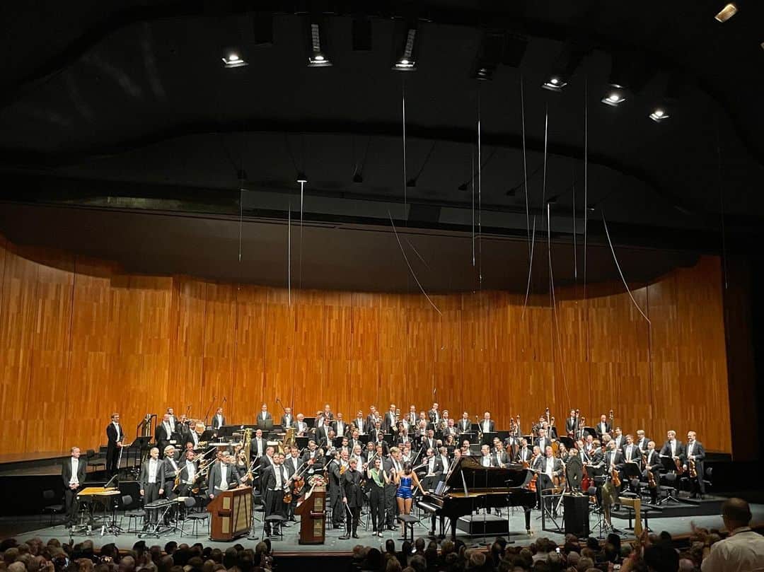 中谷美紀さんのインスタグラム写真 - (中谷美紀Instagram)「ザルツブルク音楽祭におけるウィーンフィルのコンサートは、リヒャルト・ワーグナーのオペラ「トリスタンとイゾルデ」より前奏曲、そして、オリヴィエ・メシアンによる「トゥーランガリラ交響曲」をもって全て終了しました。  エサ＝ペッカ・サロネン氏の指揮により、究極の愛を描いた「トリスタンとイゾルデ」の美しき前奏曲が情感を抑え気味に演奏されると、休憩を挟むどころか拍手で賞賛を送る隙も、余韻に浸るゆとりも与えずに、「トゥーランガリラ交響曲」が掻き鳴らされました。  調性を意図的に破壊し、メロディーのゆく末を不明確にすることで、死をもって許されざる愛を全うしようとしたトリスタンとイゾルデの悲劇をよりドラマティックに表現することに成功し、不協和音を音楽史上に解放したワーグナー。  そして、それから約100年後に、まるでアンサーソングのようにメシアンによって書かれた、10楽章からなる「トゥーランガリラ交響曲」を、11楽章の一曲のように扱ったこの度の試みは、主催者や音楽家にとってはまるで綱渡りのように危うく、それでいてエキサイティングであったことは想像に難くありません。  ヴィブラフォンや、チューブラーベルを含むと、11人のパーカッショニスト、そして、鍵盤型のグロッケンに、チェレスタを入れた大編成には、ピアノと、奇妙な音を出す電子楽器オンド・マルトノの独奏が加わります。  指揮者のサロネン氏の挑戦を受けて立つウィーンフィルのリズムと緩急が素晴らしく、愛の前に立ちはだかる険しき茨の道が見えるような、あるいは稲光りがきらめく中、荒波の上の航海をしている様を想起させられました。  また、ピアノの独奏を鮮やかにこなしたユジャ・ワン氏の超絶技巧と現代音楽への深い理解、オーケストラのリズムに呼応する感性が秀逸で、瞬く間に魅了されました。  彼女の魂に刻まれたリズム感、そして、鍵盤の高音から低音への移動に伴う重心移動の美しさはまるでダンサーのようです。  メシアンの楽譜による指示か、サロネン氏の指示かはわかりかねますが、残響をコントロールするペダルのタイミングにも鳥肌が立ちました。  彼女が難解なこの音楽の敷居を下げ、私たち聴衆に、生き生きと躍動感のある贅沢な音とリズムの遊びとして伝えてくれたように思います。  露出過剰なステージ衣装が彼女の品位を自ら貶めていると見る向きも少なからずあることは、誰よりも彼女自身が承知しているのでしょう。  心・体・技を伴い、世界中に数多いるピアニストの中でも抜きん出た才能に加え、多くの犠牲を要する努力と孤独の上に彼女の華々しいキャリアは存在しているように見受けられ、衣装云々はもはやどうでもよく思えました。  聴衆の皆様にも、サロネン氏の高度な企てはしっかりと伝わり、大喝采に迎えられた最後に、私も興奮しました。  ト音記号やヘ音記号が二つ以上ついた楽譜は読めませんし、音楽史や音楽学を体系的に学んだ訳でもなく、音楽のことなど、何も知りません。  しかし、素晴らしい生の音楽は、国境も人種も宗教も超えて、魂を震わせるものですね。  長引くコロナ禍に疲弊し、そろそろ皆様も生の音楽を希求していらっしゃる頃ではないでしょうか？  新たな1週間を、どうぞ無事にお過ごしくださいませ。  我听过奥利维尔·梅西安的《Turangalila》，由 Esa-Pekka Salonen 指挥，由维也纳爱乐乐团演奏，由王羽佳担任钢琴独奏，我爱上了演奏。   Wir haben das letzte Konzert von Wienerpihlharmoniker in Salzburgfestspiele 2022 vergnügen.  #オーストリア #ザルツブルク #ザルツブルク音楽祭 #ウィーンフィル #エサペッカサロネン #ユジャワン #トリスタンとイゾルデ #ワーグナー #オリヴィエメシアン #トゥーランガリラ交響曲 #海外暮らし #田舎暮らし #フシュル湖 #ディオール #ディオールジュエリー #ローズデヴァン #中谷美紀 #visitsalzburg #salzburgerfestspiele  #salzburgfestival  #visitaustria  #fuschlsee  #viennaphilharmonic  #esapekkasalonen  #yujawang  #countrylife #dior #diorjoaillerie  #diorjewelry  #mikinakatani」8月29日 20時27分 - mikinakatanioffiziell