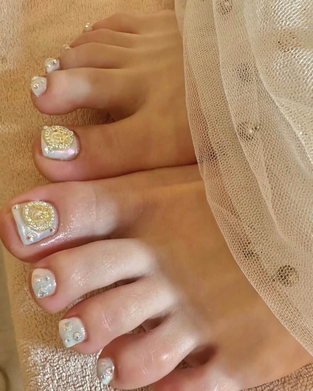 まゆぴちゅーさんのインスタグラム写真 - (まゆぴちゅーInstagram)「鬼かわDiorネイル💅💓  @yudia_totalbeauty さんで 初めてネイル行ってきた！！✨✨  待って？？え？？？  可愛すぎません？？🥲🥲💓💓💓  Diorパーツとキラキラで 最強可愛いネイルになりました🥺🥺💓💓 シャンパンピンクゴールドみたいな キラキラのベースの色もかわいい😭🧡  埋め尽くしも間開けて置いて宝石みたいに💎✨  足のネイルもホワイトパールみたいにして 親指にDiorのパーツ置いたよ🫶🏻✨  ここパーツもシールもブランド系とか たーっくさんあってすごかった🥹❤️❤️  ▶︎ @yudia_totalbeauty   ハンドネイルを担当してくれたのは @nail._azu さん💓  かんわいくしてくれてありがとうございます🙈💋 . . . #newnails #キラキラネイル #diorネイル #diorパーツ #diornails #うめつくしネイル #宝石ネイル #チェーンネイル #Vカット #vカットストーン」2月25日 22時15分 - mayu_03pichu