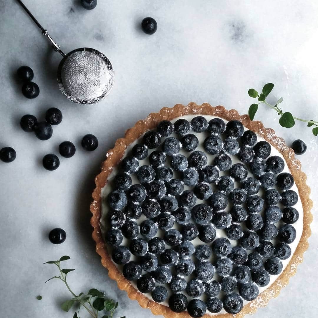 Mikaのインスタグラム：「blueberry  tarte.  ご無沙汰しております。 私は元気です。  レアチーズタルトの上にブルーベリーどっさり盛ったうちの定番おやつ。  甘いものが苦手な旦那くんもこれならワンホール食べられるそうなので、ブルーベリーの季節はかなり作っています。  今月の旦那くんの誕生日ケーキもこれ。笑  手抜きじゃないのよ！  これがいいってリクエストだったんだもの(๑´≧ڡ≦`๑)てへ  マイペースupになると思うけど これからもよろしくお願いします。」
