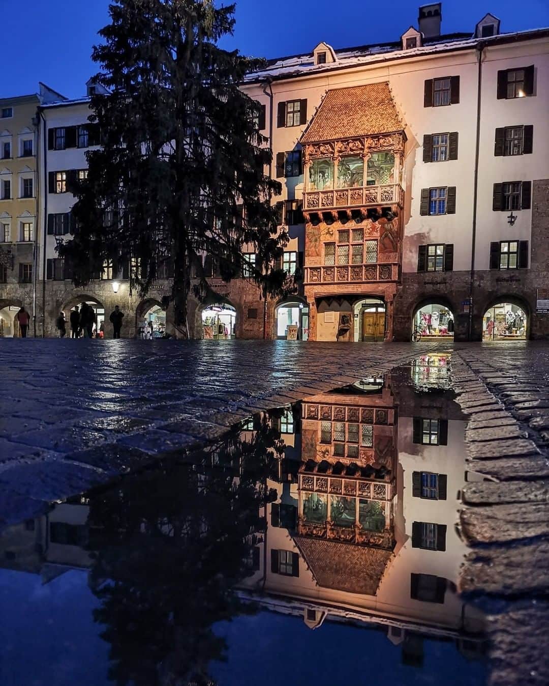 National Geographic Travelさんのインスタグラム写真 - (National Geographic TravelInstagram)「Photo by Robbie Shone @shonephoto | The iconic Golden Roof is reflected in a puddle in the heart of Innsbruck, Austria, while a Christmas tree awaits removal nearby. More than 2,600 fire-gilded copper tiles adorn the roof, which was completed in 1500.」4月13日 21時07分 - natgeotravel