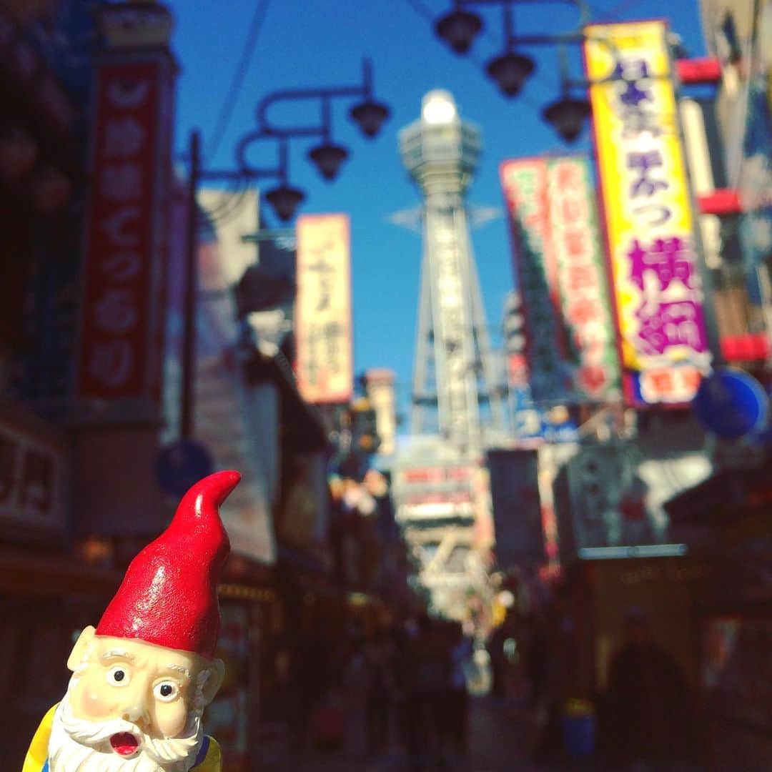 横山エリカのインスタグラム：「I was wondering where Mr. Gnome would go first🤔finally heard from him few days later...He actually decided to stop by my hometown Osaka, before leaving the country🇯🇵He took a stroll through the streets of Shinsekai, and took a picture with the iconic Tsutenkaku Tower🗼He also stuffed his face with the famous Osaka delicacy, Kushikatsu (fried skewers). And of course he followed the rule and ate it the right way👍No double dipping😉 . . ノームさんの最初の旅先はどこだろうと思っていた矢先🤔数日経ってやっと連絡がきました。日本を離れる前に私の故郷でもある大阪に立ち寄っているとの事🗼新世界を探検し、大阪のシンボル、通天閣をバックにぱしゃり📸そしてかの有名な串カツをたらふく食べて食い倒れ🤤もちろんルールをしっかり守ったそうですよ👍二度漬け禁止！ . .  #gnome #gardengnome #travellinggnome #whereismygnome #worldtraveller #roaminggnome #gnoming #gartenzwerge #freethegnome #missinggnome #amelie #travellingwithoutmoving #osaka #shinsekai #tsutenkaku #kushikatsu #whereintheworldismrgnome #ノーム人形 #ガーデンノーム #庭小人 #旅するノーム #旅するガーデンノーム #アメリ #世界旅行 #ひとり旅 #大阪 #新世界 #通天閣 #串カツ」