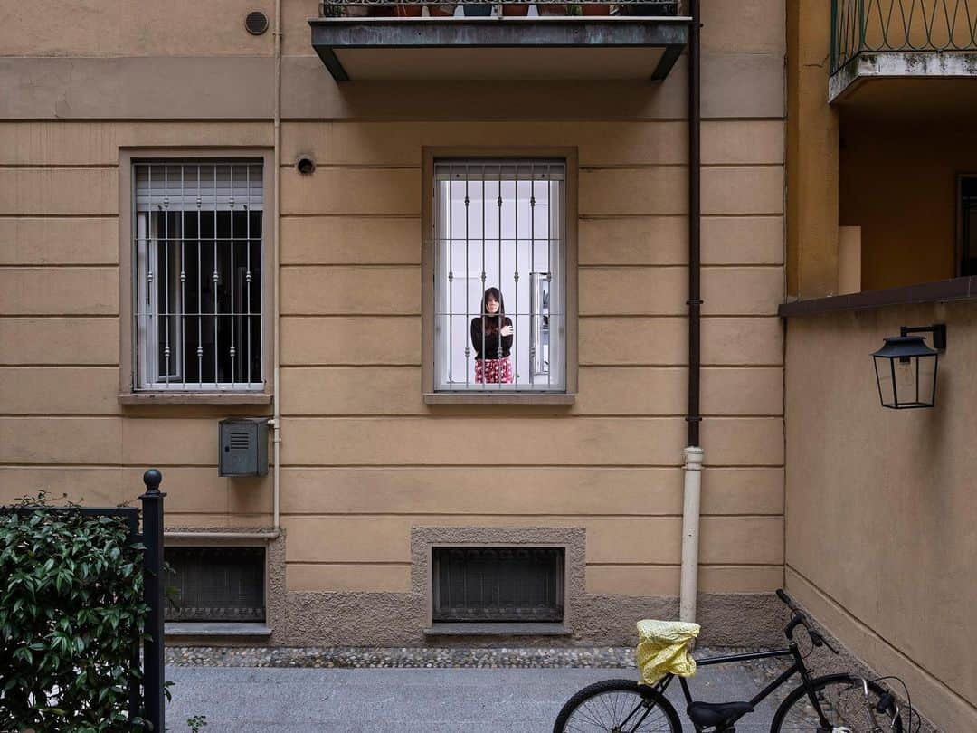 ナショナルジオグラフィックさんのインスタグラム写真 - (ナショナルジオグラフィックInstagram)「Photo by @gabrielegalimbertiphoto | Amid Italy's coronavirus emergency, I have chosen to continue working by photographing and interviewing (together with my friend Gea Scancarello) people who are locked in their Milan homes, in compliance with the quarantine imposed by the government. I left lights outside their windows, disinfecting them first. The subjects brought them inside; from outside, I directed how to position them. To take these photos, we've complied with all the necessary safeguards.  Before the quarantine started, Veronica Strazzari, 36, says she can’t remember ever spending a whole day at home. She lives in a 30-square-meters studio apartment, and since space is tight she spends a lot of time outside. With the outbreak of the epidemic, the company she works for—Prada—closed its offices, and she's pleasure in living in her home. “I’m discovering a dimension I’ve never experienced before, and I’m also surprised that I’m not anxious about the situation at all,” she says. She keeps some daily rituals: “I read a lot, every night I do yoga and pilates, and twice a week a total body workout with fan app. And then I spend a lot of time on Instagram, following new accounts. Yesterday, for example, I signed up for a tour-operator channel that offers travel videos.” Also, she continues, “since I started the quarantine I’ve been keeping a diary of the things I learn every day. The most beautiful page is that of March 15: I had just finished a James Nachtwey book, titled Memory, which talks about photography as profound isolation, a necessary silence for understanding. I found it to be perfectly in tune with this situation.” Follow @natgeointhefield for real-time coverage of this developing story from photographers around the world.  Check out Nat Geo's link in bio for more on this story.」3月26日 2時02分 - natgeo