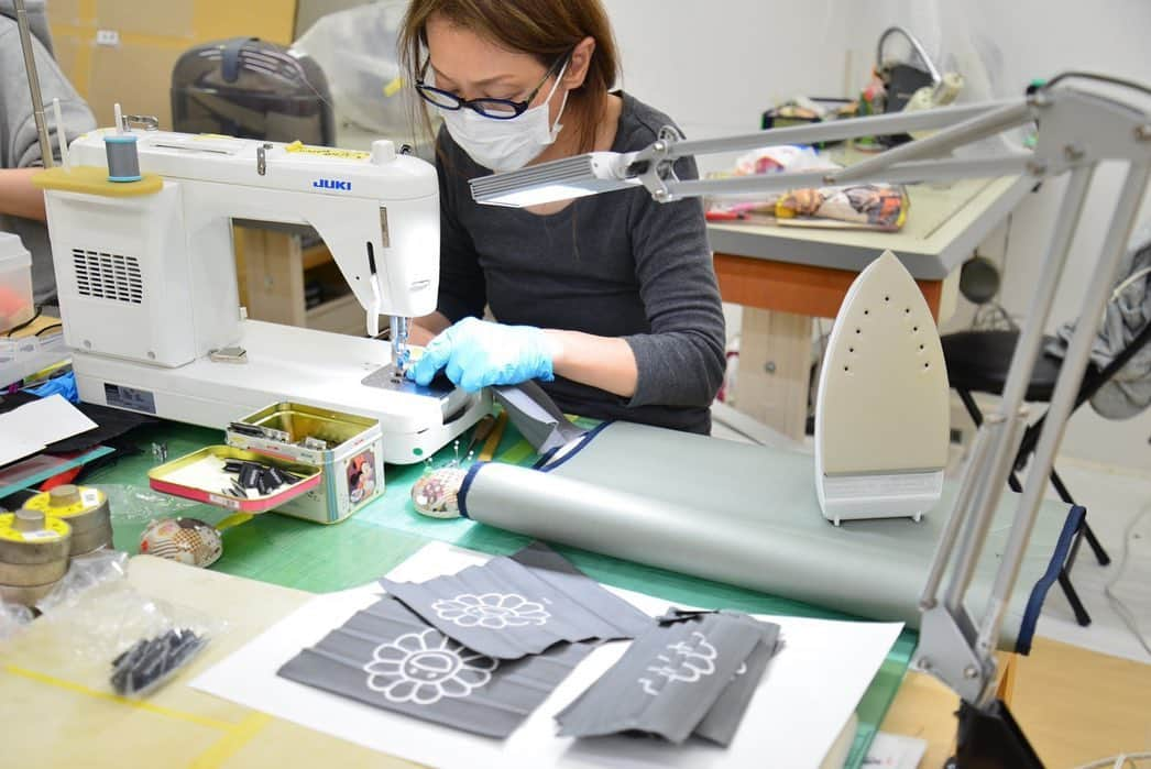 村上隆さんのインスタグラム写真 - (村上隆Instagram)「For the past week, in the bag production department located within my painting studio in Miyoshi, Saitama Prefecture, a team has been working on making masks to be supplied to the Kaikai Kiki staff.  In and around Tokyo we haven’t experienced any lockdowns yet and at my studio in Saitama, just north of Tokyo, we have been making an enormous painting for a major exhibition at the Mori Art Museum @moriartmuseum , titled Stars, which was meant to be an accessible presentation by the Japanese art world aimed at the overseas guests who were to pour into the country for the now-postponed Olympics. I was having a difficult time securing disposable masks for my staff working around the clock, so I decided to make them in-house.  These are washable, reusable masks—though of course washing and drying them takes a bit of work—and they have been distributed among the staff.  The first batch has the flower printed on them. The studio is filled with tension but it seems that some smiles have returned. 🙏🙏🙏 translation: @tabi_the_fat」3月26日 14時48分 - takashipom