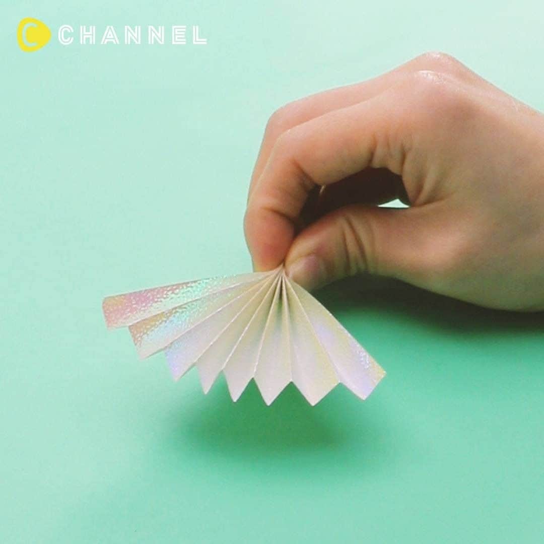 C CHANNEL-Art&Studyのインスタグラム：「Make and Play! DIY Paper Fan 作って遊べる!  飛び出すペーパーファン . 🎨Follow me👉 @cchannel_artandstudy 🎵 💡Check👉 @cchannel_girls 🎶 📲C CHANNELのアプリもよろしくお願いします💕 . 【What You Need】 ・ Origami 2 sheets ・ One piece of 21cm x 18cm drawing paper ・ Two pieces of 10cm x 10cm drawing paper ・ 4 to 6 line tapes ・ Two embroidery threads around 30cm ・Masking tape ・Double-sided tape . 【Steps】 1. Cut the origami in half and make a wave fold. 2. Make four 1s, secure both ends with double-sided tape and combine them into one. 3. Bundle the two ends with double-sided tape. 4. Round 3 on the edge of 21cm x 18cm drawing paper. 5. Wrap the double-sided tape around the base, paste the line tape there, and paste the masking tape from above. 6. Attach double-sided tape to both ends of the folded origami paper and stop the embroidery thread. 7. Roll a piece of 10cm x 10cm drawing paper on top of the stick, and apply double-sided tape. 8. At 7 apply the embroidery thread downward so that the line tape is applied once, folded down and turned up. 9. Round 10cm x 10cm drawing paper from the top of 8. 10. Add curl to the line tape and cut the extra length embroidery thread to complete. .  パーティの飾りとして人気のペーパーファン。 一工夫加えたら楽しいおもちゃに大変身!! お友達や姉妹、お子さんと作って遊んでみてください♡ . 【材料】 ・折り紙2枚 ・21cm×18cm画用紙1枚 ・10cm×10cm画用紙2枚 ・ラインテープ4~6本 ・30cm前後の刺繍糸2本 ・マスキングテープ ・両面テープ . 【手順】 1. 折り紙を半分に切って、波折りにする。 2. 1を4つ作り、両面テープで両端をとめ1本にまとめる。 3. 2の端を両面テープで束ねる。 4. 21cm×18cmの画用紙の端に3をつけて丸める。 5. 根元に両面テープを巻きつけ、そこにラインテープを貼り付けていき、マスキングテープを上から貼る。 6. 波折りした折り紙の両端に両面テープを貼り、刺繍糸をとめる。 7. 10cm×10cmの画用紙を1枚、ステッキの上から重ねて巻き、両面テープを貼る。 8. 7をズラし、ラインテープは一度下に貼って折り返してから上向きになるように、刺繍糸は下に向かって貼る。 9. 8の上から10cm×10cmの画用紙を巻く。 10.ラインテープにカールをつけて、 余分な長さの刺繍糸はカットして完成。 . 材料は、文房具店や東急ハンズ、ロフトなどで購入できます。 . . #DIY#doityourself#diyideas#crafts#crafting#instacraft#crafter#crafty#handmade#handcrafted#handmadecrafts#handmadeaccessories#ideas#resin#resinart#resina#Fantastic#incredible#creative#heart#howto#tutorial#dreamy#glitter#paperclaft#pink#ペーパーファン#手作りおもちゃ#ゆめかわ」