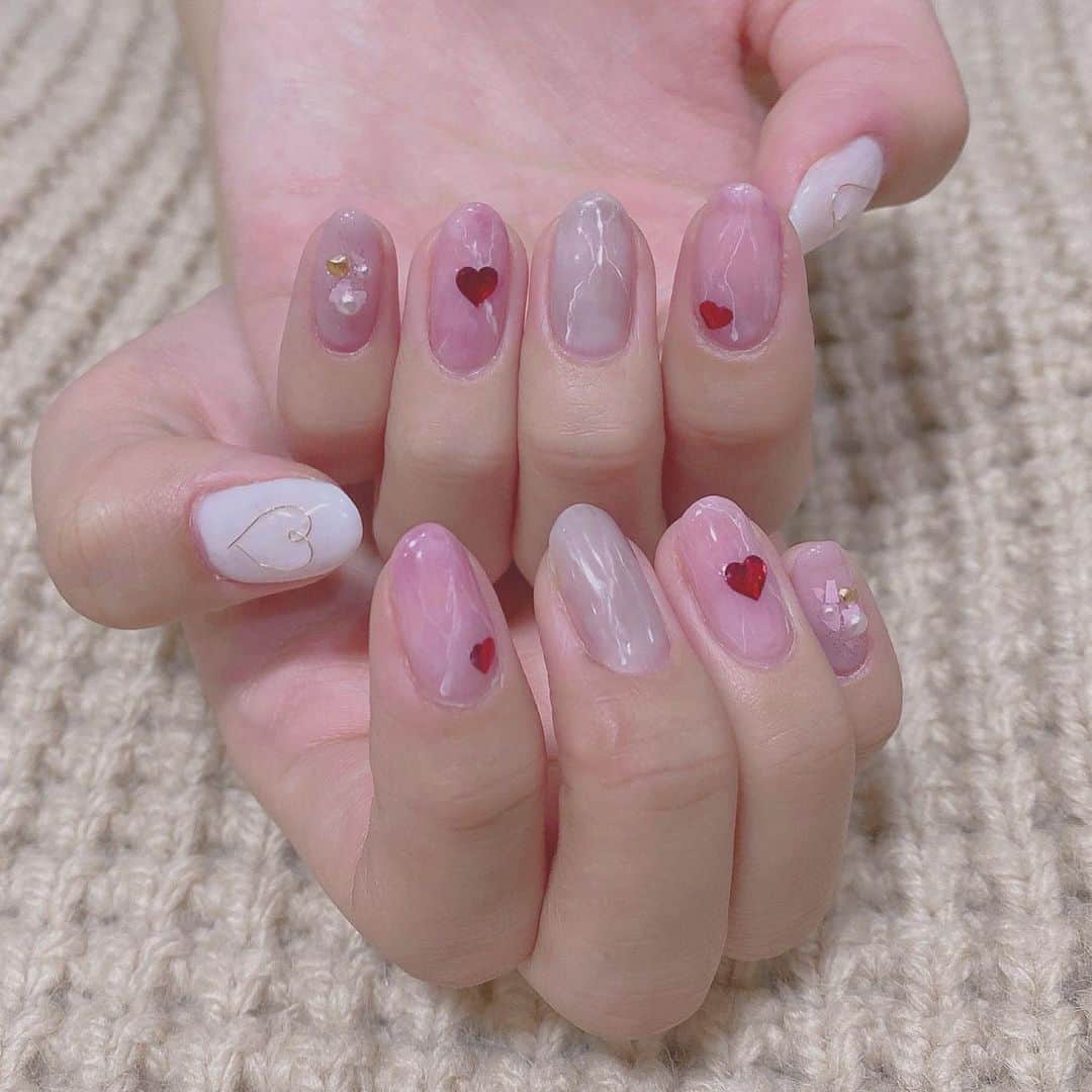 宮園明希のインスタグラム：「.﻿ ピンク系のハートネイル❤︎﻿ ﻿ 馴染みやすいカラーにパーツをつけてもらったり、大理石調にしてもらいました☺︎﻿ ﻿親指のワイヤーでつけてもらったハートがポイントです♡  可愛くてお気に入りでした！！😚」