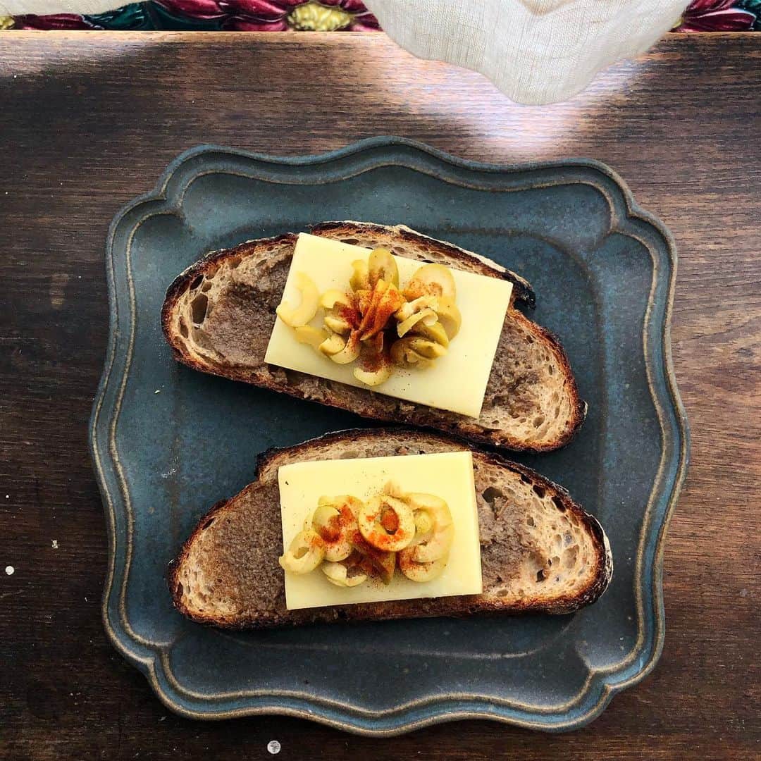 CHIPPRUSONのインスタグラム：「きのこペースト🍄コンテチーズ、オリーブを乗せたカンパーニュ。オリーブの代わりにアボカド乗せたら更に美味しかった。  ペーストやクリーム、ジャムとか保存がきくもの作るの好きだ。作ったら満足して大体忘れてしまうのだけど、これは美味しいのでオススメです。  きのこペースト  ブラウンマッシュルーム2パック、舞茸1パック、ニンニク二片を多目のオリーブオイルでじっくり一時間位炒める。バルサミコ酢1カップ、ラム酒大さじ2（または、赤ワイン、ブランデー）、メープルシロップ大さじ1（または、はちみつ）を3分の1以下に煮詰めてシロップにしたものを少々、好みでオリーブオイル、しっかりめの塩味になるように塩を加えてフードプロセッサーにかけてペースト状にする。冷蔵庫で一晩寝かせる。パンに塗ったりクリームパスタに加えたりしてみてくださいね。  バルサミコ酢のシロップは万能旨味調味料。ビーフシチュー、カレー、ボロネーゼソースなど、しっかりした味付けのお料理の隠し味に最適。鷄の照り焼きサンドのタレにもちょっと加えるととても美味しくなりますよ🙌🎵私はいつも赤ワインとはちみつで作るんだけど、今回はラム酒を使ってみました。」