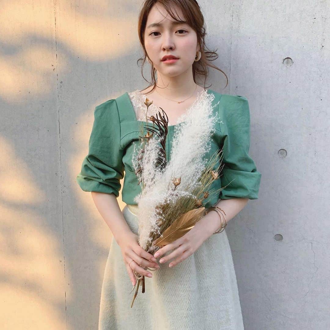大野愛友佳のインスタグラム：「わたしのお部屋の1番大切なドライフラワーと🌼 日向ぼっこはおうちのお庭で。 . ゴールドの羽が入ってて、 ホワイトとブラウンですき。 . . グリーンのトップスは あゆちゃん @ayupichikitchen と あかねっち @iam.akanetan の 新しいブランドのお洋服。 @comomi_official . 胸元はスクエアだったから ベージュのレースを重ねてみました🍐 . わたしはボリュームのために 肘までまくってるけど、 実は長袖だからオールシーズン着れるの✔️ . グリーンカラーのデニム生地って新鮮◎ . . おうち時間使って、 インテリアの見直しと 収納の見直しがたのしいです◡̈ . . #日向ぼっこ#おうち時間を楽しむ#お庭遊び　 #ベランダからの眺め#ドライフラワースワッグ #春コーデ#スクエアネック#グリーンコーデ #自粛生活#緑コーデ#ベランダ菜園 #オールグリーン#お花のある暮らし #暖かい日差し#空気の入れ替え」
