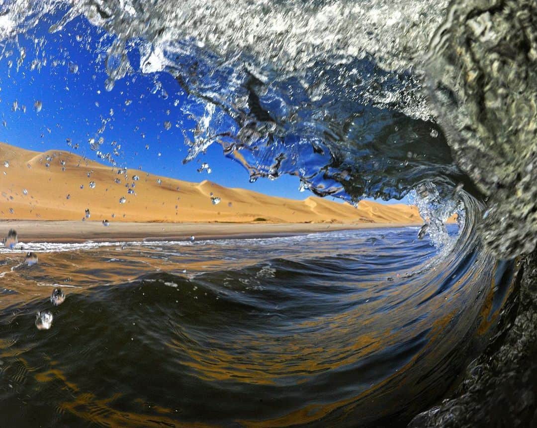 Thomas Peschakのインスタグラム：「The icy and wild Atlantic Ocean collides with the Namib desert along Namibia's Coast. Shot on assignment for @natgeo for ‘Cross Currents’ my Dec 2014 story on Southern African Marine Reserves. #namibia #surfing #wave #barrel #africa」