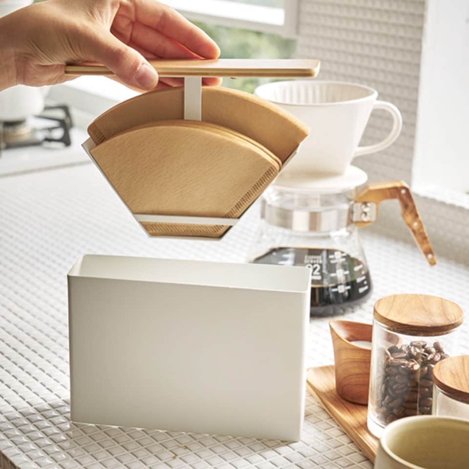 yamazaki_japanさんのインスタグラム写真 - (yamazaki_japanInstagram)「温もりある木目と白の組み合わせ上品なコーヒーペーパーフィルターケース。「コーヒーペーパーフィルターケース トスカ」のご紹介です。 . 収納場所に困るコーヒーペーパーフィルターをスマートに収納できるケースです。 フタと一体になったホルダーにフィルターをセットする構造になっているので、フタを引き上げるだけでフィルターを取り出すことができます。 . 収納すればほこりやゴミから守ることができ、衛生的にお使いいただけます。底面は穴が開いているので、底にほこりが溜まることもありません。 . ホルダーは真ん中に仕切りがあるので1～2杯用、3～4杯用と分けて収納する事ができます。ホルダーの底の穴にフィルターを差し込むので円すい型にも対応◎ 北欧風のデザインで、ダイニングテーブルや、キッチンカウンターなどに出しっぱなしでも気にならないので見せる収納にもピッタリです。 . ■SIZE　約W18.5×D5.7×H14cm　■収納可能数　扇形：1～2・2～4杯用ペーパーフィルター約100枚(片方 約50枚)　円錐形：1～2・2～4杯用ペーパーフィルター約60枚(片方 約30枚) . --------------------------------- 山崎実業のコラムサイト「Simple Life Lab.」も運営中◎ 暮らしのアイデアや、漫画ヤマクマちゃんなど様々なコンテンツが掲載されています。 是非ご覧ください。 https://www.yamajitsu.co.jp/lab/ --------------------------------- .  #home#tosca#コーヒーペーパーフィルター収納#見せる収納#コーヒーペーパーフィルターケース#キッチントップ#キッチン収納#キッチン#暮らし#丁寧な暮らし#シンプルライフ#おうち#シンプル#モダン#便利#おしゃれ #雑貨#北欧風#天然木 #yamazaki #山崎実業」8月7日 12時02分 - yamazaki.home.channel