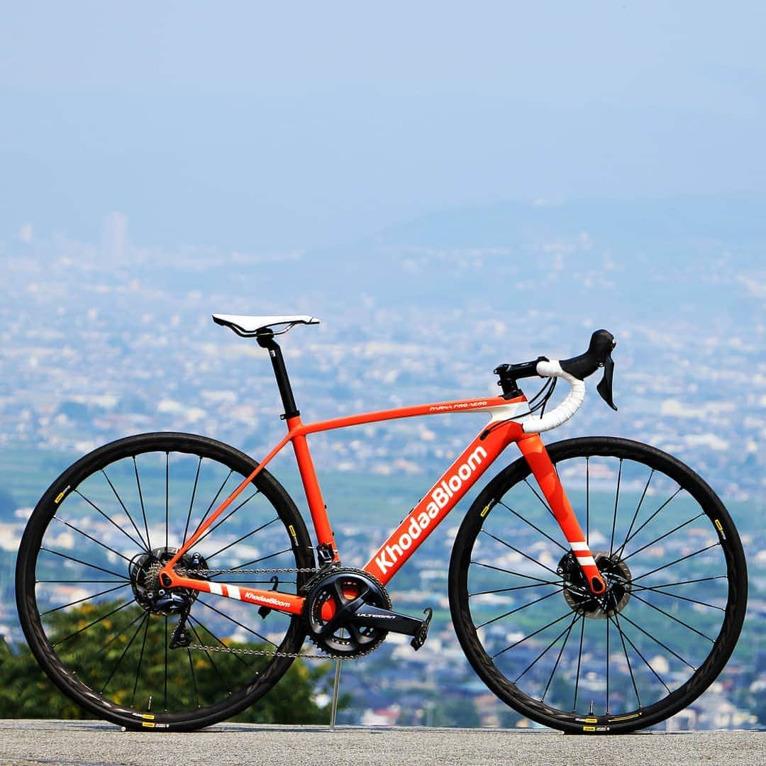 KhodaaBloomのインスタグラム：「日本人の脚にあったレーシングディスクロードバイク「FARNA PRO AERO DISC」 . 「FARNA PRO AERO DISC」を開発するにあたってKhodaaBloomが目指したのは、ベースとなる「FARNA PRO AERO」が持つ「クリテリウムレースに向いた高い剛性感から生み出される加速性能」や「日本人レーサーが乗って、レースの最後まで戦える剛性バランス」といった特性を守りながらディスクブレーキを搭載した「レーシングロードバイク」としてさらなる進化を果たすことです。 . 「FARNA PRO AERO DISC」はディスクブレーキを搭載することでの低重心化による安定感の向上や全天候への対応、ブレーキブリッジを廃することで快適性の向上を実現しました。加えて、スルーアクスルシステムを採用することで車軸に高い剛性と強度を確保し、レースのシビアなカーブにもより意のままに走るバイクとなりました。ディスクブレーキによる単なる重量増加を物ともしない、高い走行性能を「FARNA PRO AERO DISC」は獲得しました。 日本人の脚にあった「レーシングディスクロードバイク」として「FARNA PRO AERO DISC」は誕生したのです。 . #khodaabloom #コーダーブルーム #FARNA　#FARNAPROAERODISC」