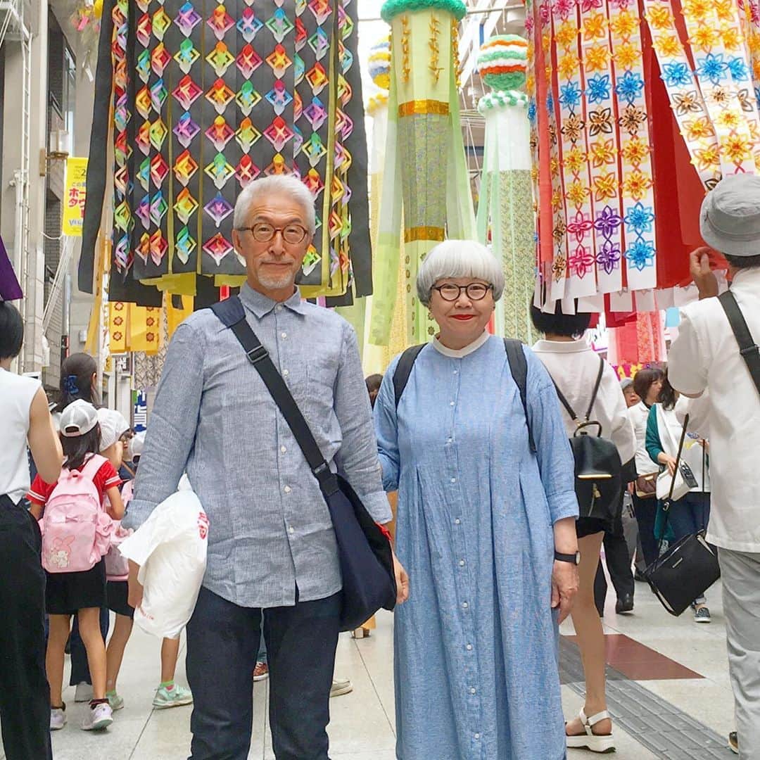 のインスタグラム：「8月6日〜8日まで開催された『仙台七夕まつり』を見に行って来ました🎋🎋🎋 吹き流しの間をくぐりながら、色とりどりの七夕飾りを鑑賞して歩きました。 以前「Kappo 仙台闊歩」の取材で、七夕飾りを製作して130年の老舗紙問屋『鳴海屋紙商事』さんを訪ねて、製作現場を見学させていただいたので、今年は例年に増して一つ一つのくす玉や吹き流しを興味深く眺めました。 それぞれに趣向が凝らされ、手の込んだ七夕飾りに感嘆するばかりでした😍😍 仙台七夕まつりの飾りは、ビニールやプラスチックではなく和紙で作られているので、やはり趣があって美しいなぁと思いました。 2人の写真は、ボランティアの方に撮っていただきました。 ・ #仙台七夕まつり #夫婦 #60代 #ファッション #コーディネート #リンクコーデ #夫婦コーデ #グレイヘア #白髪 #共白髪 #couple #over60 #fashion #coordinate #instafashion #instagramjapan #greyhair #bonpon511」