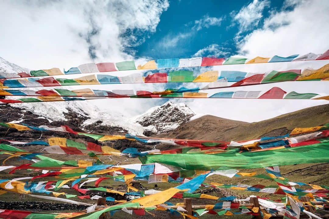 National Geographic Travelさんのインスタグラム写真 - (National Geographic TravelInstagram)「Photo by @andrea_frazzetta | Tibet, the massive Noijin Kangsang glacier, 7,206 metres (23,641ft) above sea level, in the Lhagoi Kangri chain. Mt.Noijin Kangsang is the closest major Himalayan peak to Lhasa, the capital of Tibet. The mount is known as a holy peak for the local Tibetans and people used to burn incense and put prayer flags on the peak. Tibetan prayer flags are traditionally used to promote peace, wisdom, compassion, and strength. Tibetans believe the wind will blow the prayers and mantras in to the surroundings, spreading goodwill and compassion. To see more photos from my travels, follow me @andrea_frazzetta #tibet #glacier #blowinginthewind」8月8日 16時04分 - natgeotravel