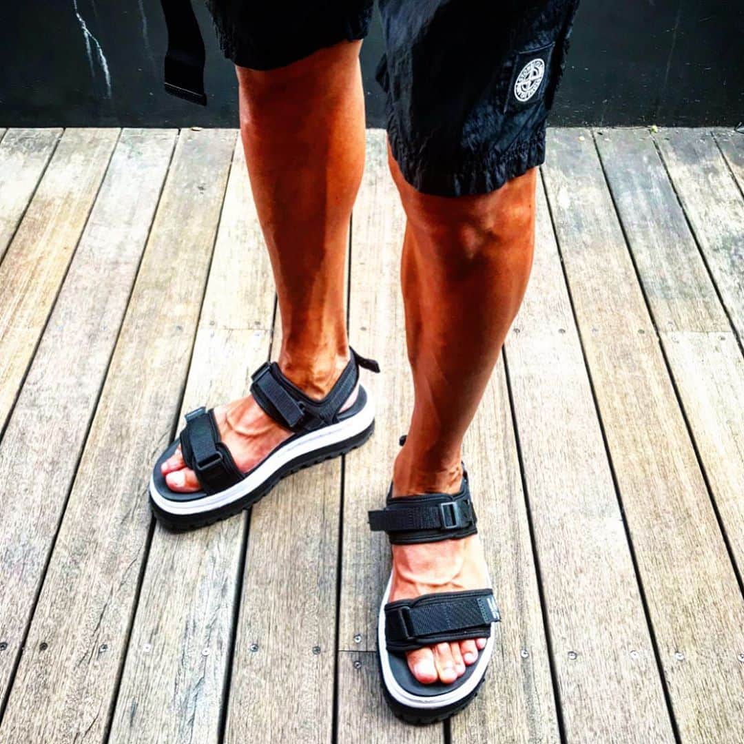 のインスタグラム：「【お気に入りのショートパンツ】朝まで原稿書いて、そのまま寝ずに朝から撮影。ようやく終了と思って外に出たら、激暑5段‼️ 本当暑いから今日はショートパンツにスポーツサンダル、クロスクローゼットの黒のビッグTでタピオカ鉄観音ミルクティーをがぶ飲みしてます（笑） っていうか「stoneisland（ストーンアイランド）」のショートパンツめちゃイイ感じ。シンプルな真っ黒で、ロゴも小さいし、クシャっとしたメタルナイロンの素材感も良いし、シルエットも良いし、インナーもついてるから水着にもなるし、肌にもペタペタまとわりつかないし、マジで最悪に最高！ どっちやねんホンマ。誰か同じのもう1枚買ってくれませんか？ オナシャス。ちなみに、ピローんと垂れ下がってるのはPRADAのアレです。知らんけど。  ショートパンツ3万円(税抜)／ストーンアイランド（ストーンアイランド東京☎︎03-6427-6148）  @stoneisland_official  @stoneisland_italia_  @stoneislandcentral  #stoneisland @crossclothet_official  #crossclothet @prada  @yoshimasa_hoshiba  #yoshimasahoshiba  #干場義雅 @forzastylecom  #FORZASTYLE  #shortpants  #オナシャス #ショートパンツ #ショートパンツコーデ #夏コーデ #夏コーデメンズ #靴魂 #あなたの靴見せてください」