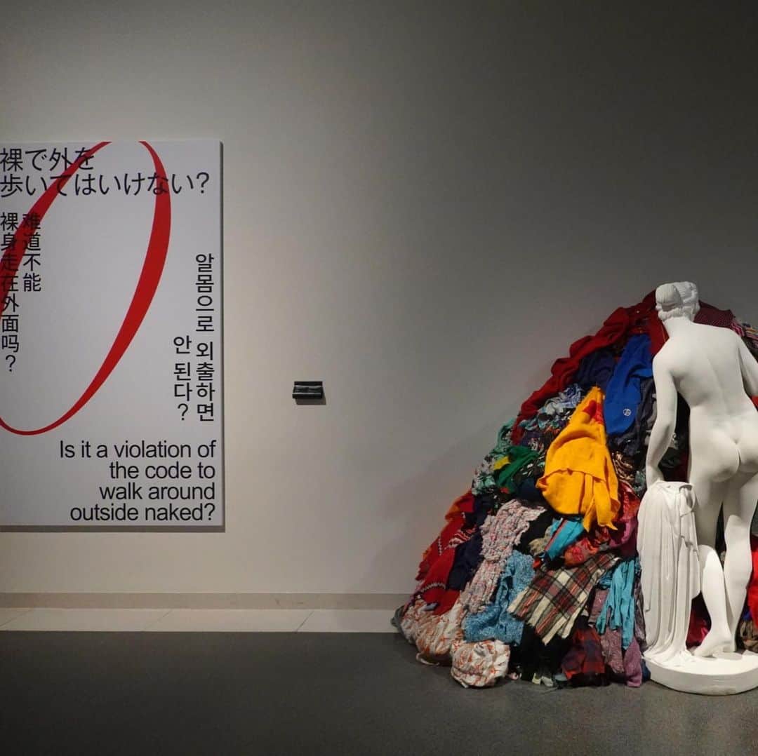 林信行のインスタグラム：「「ただマネキンにブランドの服を着せた展示にしたくなかった」 美術館ならではの批評性のあるファッション展を目指した 「ドレス・コード？―着る人たちのゲーム」展（8/9-10/14）。 今日から京都国立近代美術館で始まります。  昭和55年から５年に1度のペースでファッション系の展覧会を開いてきたという京都の国立近代美術館#京都服飾文化財団 の日本初公開の所蔵品300点強を使った展覧会。 同館の牧口主任研究員は「最近はハイブランドのメゾンが非常に優れ展覧会を開くようになってきている。そうした中で美術館だからこそできるファッションの展覧会とは何かを考え、『批評性』を持たせること」という結論に至り本展を企画した、と言う。  プロローグ＋12章で構成された展覧会。 その展覧会でプロローグを飾るのはミケランジェロ・ピストンの「ぼろぎれのヴィーナス」。 大量の服の山の前に裸のヴィーナス像が佇む作品。 作者にその意味や意図はなかったが、まるで大量生産、大量消費、大量廃棄のファーストファッションで捨てられた服の山に見える。 そして、その横にプロローグのテーマ 「裸で外を歩いてはいけない？」 この後、第１章 「高貴な振る舞いをしなければならない？」とビジネススーツや貴族の服が 「働かざる者、着るべからず？」で労働服が…と言った感じで展覧会が続き、 途中版からはストリートファッションの展示も多くなり、おしゃれなホームレスの写真なども登場する。  ブランドロゴの象徴としての意味合いを問うた「見極める眼を持たなければならない？」と言う章も面白く、ただロゴが２つ並ぶだけのブランドコラボ商品の展示などを見ると「ブランド」とは何なのだろう？と考えさせられる。 ちなみに先日、ちょうど誰かとこの話をしていた（角尾さんが話していたのかな？）。 最近のファッションでは、面白いアイテムが出てもすぐにその意匠がファーストファッションに真似されてしまう。ファッションの意匠は知的所有権が保護されていない。しかし、ロゴが入ると別で、だから最近、ロゴを大きくあしらったファッションアイテムが多いのだと言う。そうして記号化されたファッション性が、今度はその記号同士でコラボを始めるが、これにどれほどの意味があるのだろう。 「他人の眼を気にしなければならない？」と言う章ではハンス・エイケルブームがパリの様々な場所に同じ時間帯にいた似た格好をしている人々の写真を集めたコラージュがズラーっと並ぶ。 人と違う見た目にしようと選んだはずのファッションが、結局、他の誰かと（しかも、ここまで）被っていることの悲劇が膨大な量展示されている。  今回、出展作家の中にアンリアレイジ（森永邦彦）やユイマ ナカザト（中里唯馬）、リトンアフタワーズ（山縣良和）といったお馴染みの若手たちの名前を見かけたのでレセプションで会えるかと楽しみにしていたが、今回は京都服飾文化財団（KCI）のコレクションからの展示ということで、レセプションに参加しているデザイナーはあまりいなかった。 その代わり遭遇してビックリしたのが来年のベネチア建築ビエンナーレにも選出された建築家の 元木大輔さん。今回の展示の空間デザインを行なっている。  また最近、ワコールのオフィスの空間演出を手掛けたアーティストの ミヤケマイさんとも久々の再会を果たした。  京都国立近代美術館が投げた変化球が、ファッションの世界にどんな話題を巻き起こすのだろう！？ （ちなみに京都国立近代美術館、元木さんの話によれば青山スパイラルと同じ頃の槇文彦建築で、両方のコンペに応募したら両方通って同時に手掛けたらしく、階段とか見ると両方の建築の似ているところがたくさんあるらしい。 東京から同館を訪れる人は、ぜひ、そんな建築的な楽しみ方も一緒に味わってもらえればと思う）。 【特別な許可をもらって撮影しています。展覧会は撮影コーナーはありますが、原則 撮影禁止です】」