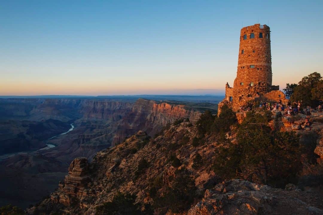 National Geographic Travelさんのインスタグラム写真 - (National Geographic TravelInstagram)「Photo by @MichaelGeorge | Visitors gather at sunset on the Grand Canyon south rim near the Desert View Watchtower. The watchtower was built by Mary Colter in 1932 in the style of Ancestral Puebloan towers. As the sun sets, the structure is cast in a deep golden glow. #grandcanyon #desertviewwatchtower #arizona #sunset」8月10日 10時01分 - natgeotravel