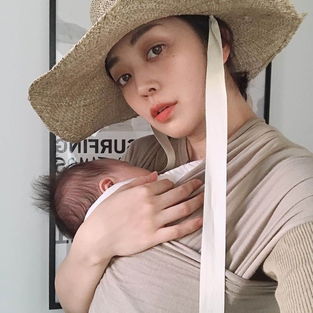 濱中鮎子のインスタグラム：「不器用過ぎて、抱っこ紐に苦戦。 今日はお天気がもったので、夕方家の近所を少しお散歩。(緊張)  #sollybaby #柄物も欲しいな #チャイさまの毛問題でベージュ一択 #bobawrapより薄手で夏向き #腹回りは未だ妊婦  #シタジキで起こした静電気並みの髪の毛 #発想が昭和  #腰痛 #骨盤矯正行きたい  #clydeのハットは @chaos_tokyo.jp  にて。  #お嬢抱っこしたら寝た #昼間は片時も寝ないため離れられない」
