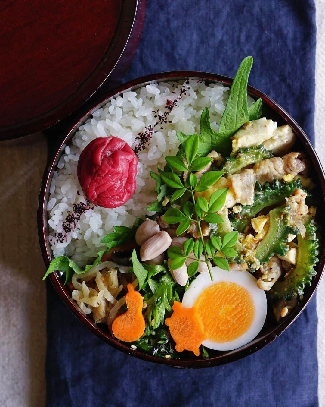 Ryoko Yunokiのインスタグラム：「+ + + Stir-fried bitter gourd, tofu and pork bento/ゴーヤチャンプルー弁当 . *rice and umeboshi *stir-fried bitter gourd, tofu and pork *hard-boiled egg *boiled peanuts *dashi-simmered dried daikon and veggies *shungiku leaves and shio-kombu salad . ＊ご飯と梅干し ＊ゴーヤチャンプルー ＊茹で卵 ＊茹でピーナッツ ＊切り干し大根と野菜の煮物 ＊春菊と塩昆布のサラダ . . Before stir-frying bitter gourd and tofu, cook tofu in a microwave for a few minutes to remove excess moisture. + + + #bento #お弁当 #丸の内弁当 #f52grams #曲げわっぱ #井川メンパ」