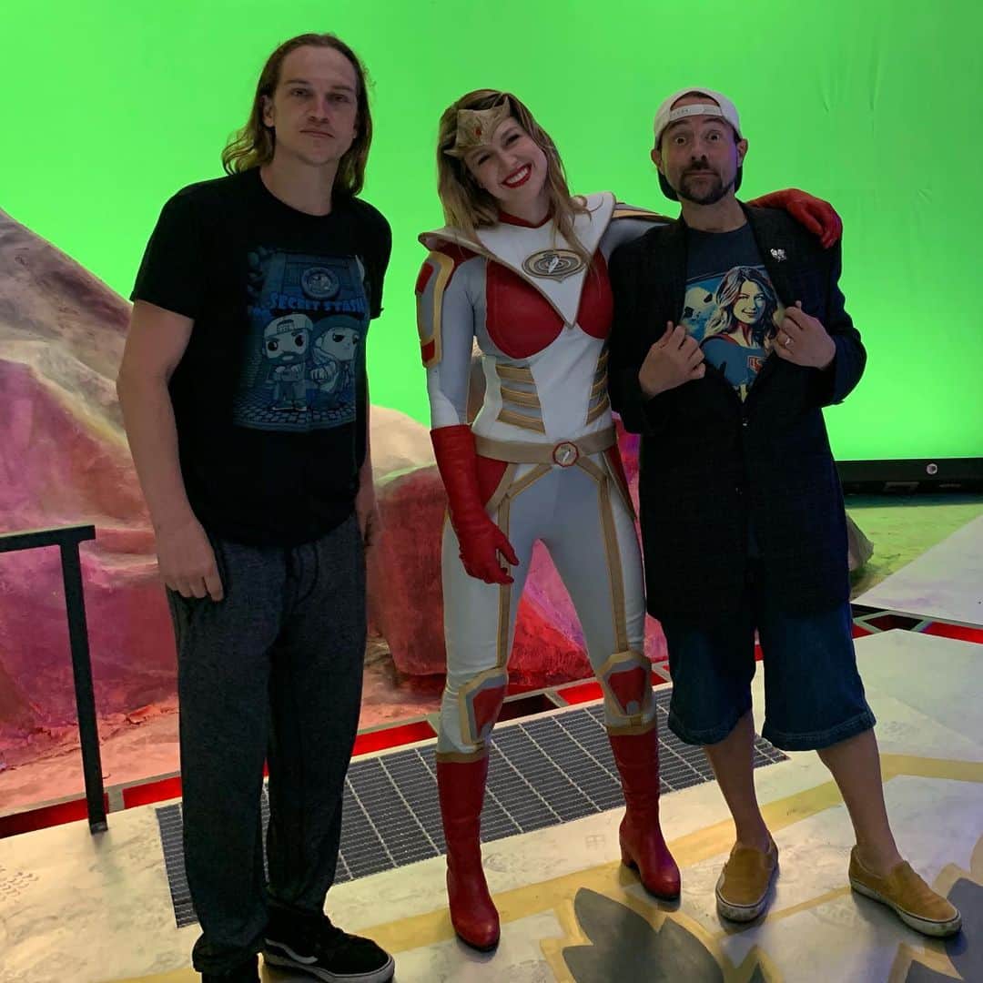 ケヴィン・スミスのインスタグラム：「IT’S A (SUPER) GIRL! The majority of you guessed correctly: @melissabenoist, one of my favorite actresses in the world, indeed takes on the mantle of Chronic in our rebooted #bluntmanandchronic movie within @jayandsilentbob Reboot! (And we gave her some pants *before* the good folks at @supergirlcw!) I have loved working with Me-Me since I “directed” her in my first ep, #supergirllives. Number One on the call sheet sets the tone for the rest of production - and if that Number One is a tool, the set is a miserable place to be. But Melissa is the most exemplary and gracious Number One I ever met. She’s incredibly kind to EVERYONE in the cast and crew and she never complains about the long-ass hours, even when she’s hanging from ropes high above the ground. Then she opens up her mouth to act and you realize she’s that rare complete package in this business: true talent and true warmth. Some actors and actresses have a “process” that can be disruptive or alienating. Melissa doesn’t have to imposition anyone to be good at her job: she’s a natural. So naturally, two years ago, I asked her to be in #jayandsilentbobreboot. Melissa was the first person I asked to be in the flick (aside from @jaymewes and @harleyquinnsmith) and though it took a minute to get to the set, when we rolled cameras, she was Charm City! I saw her in the trailer in costume before we started shooting and the Last Daughter of Krypton gushed “When you asked me to be in the movie, you didn’t tell me I get to wear a cool costume too!” God, I love this kid - she’s the absolute light of the world. (And since her boyfriend is also *my* boyfriend, you might keep an eye out for a @christophrwood cameo too!) You’ll see Melissa’s Chronic and the finished #bluntcave in the #jayandsilentbobreboot trailer when it drops this weekend in Hall H at @comic_con! But until then, check the third pic to see a cameo of an infamous web portal last seen in #jayandsilentbobstrikeback! #KevinSmith #MelissaBenoist #supergirl #cw #arrowverse #JasonMewes #jaymewes #comiccon」