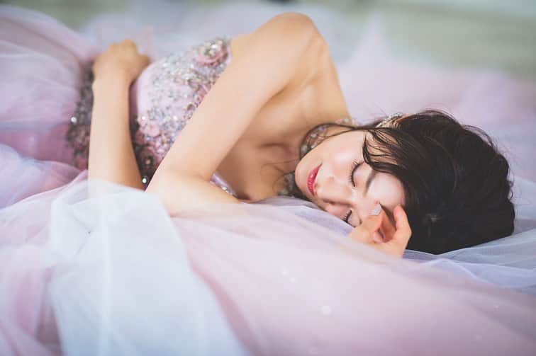 yumikatsuraのインスタグラム：「*﻿ 胸元のビジューがまるで宝石のようにキラキラと輝くドレス﻿ ﻿ 甘すぎないニュアンスカラーの中にも﻿ 意志のある女性らしさを感じます✨﻿ ﻿ ふんわりとしたドレスに包まれて﻿ 眠るショットも記念に納めて📸💗﻿ ﻿ ﻿ ﻿ ﻿ -------------------------﻿ 【AK10805】﻿ 東京本店 TEL:03-3403-7831 大阪本店 TEL:06-6245-1120 .﻿ .﻿ .﻿ #yumikatsura #ユミカツラ #桂由美 #ウェディングドレス #ユミブライズ  #YumiBrides#wedding#カラードレス#フォトウエディング#ブライダルフォト﻿ #ウェディングヘア#ブライダルヘア#花嫁ヘア#大人ウェディング#プリンセスドレス﻿ #ロケーションフォトウェディング#ピンクドレス#カラードレス#カラードレス試着﻿ #バックリボン#バックリボンドレス#バックスタイル#ビジュー#ビジュードレス#大人婚#2次会ドレス#backribbon#ドレス試着レポ#プレ花嫁#2020年春婚」