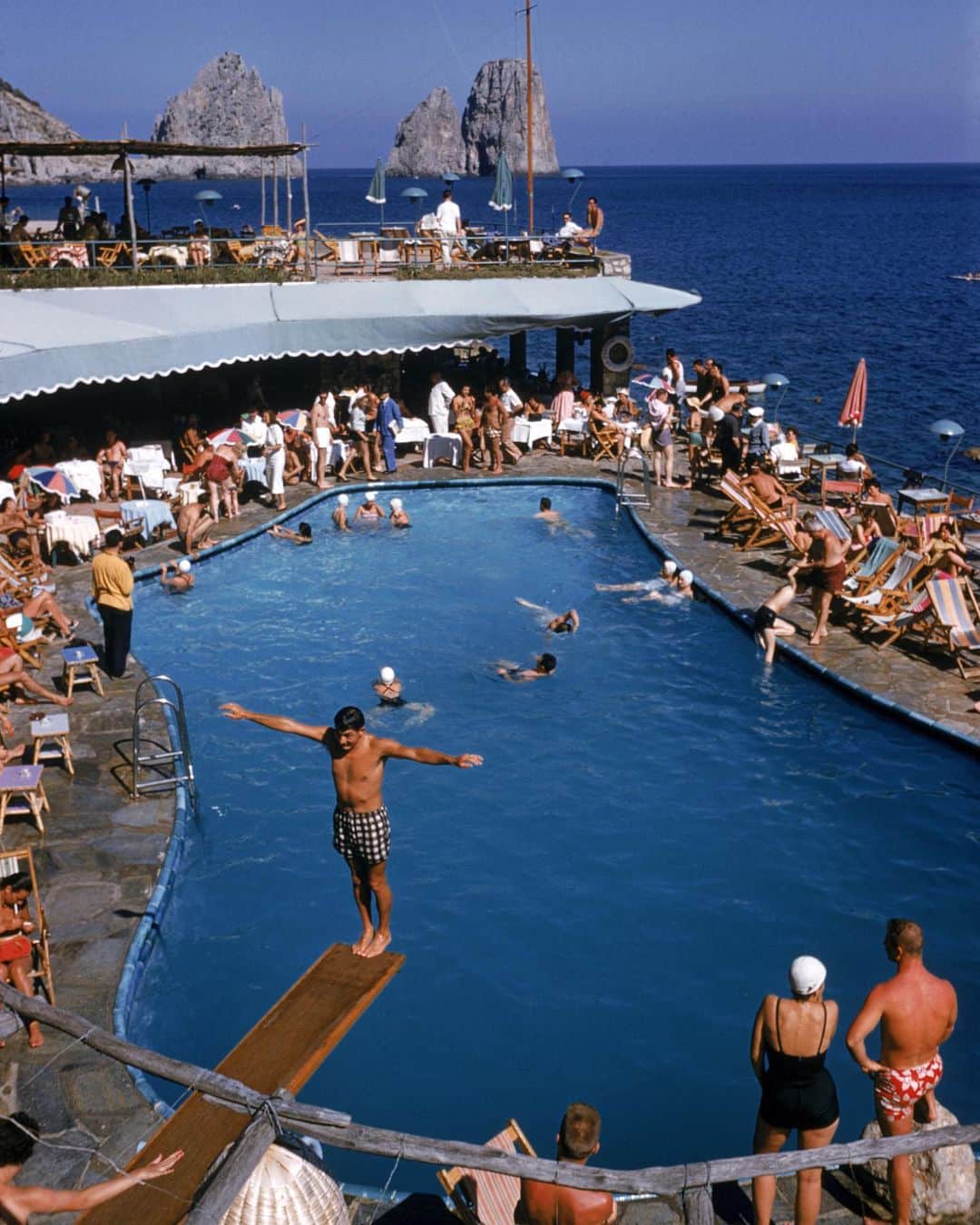 Vogue Parisさんのインスタグラム写真 - (Vogue ParisInstagram)「Slim Aarons spent decades travelling the world shooting the most glamorous people and places. As the holidays get closer, we’re throwing back to 1954 and this beach club at the Marina Piccola in Capri that’s as busy today as it was back then Photo by #SlimAarons  #Summer」7月19日 1時52分 - voguefrance