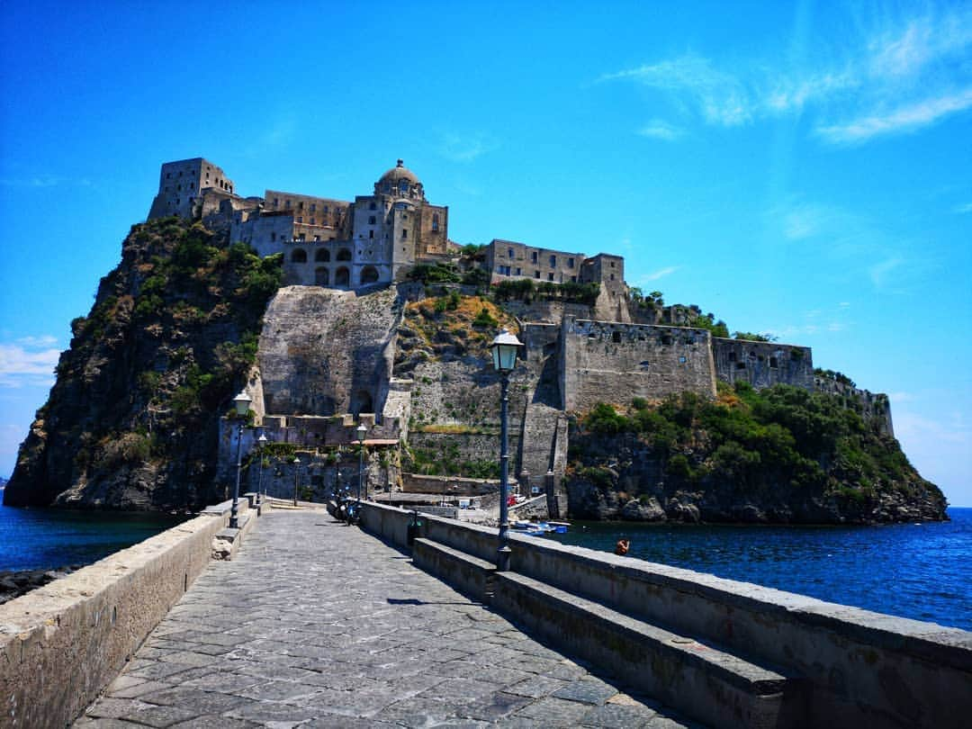 ジャスティン・マッテラさんのインスタグラム写真 - (ジャスティン・マッテラInstagram)「Il castello Aragonese di Ischia andrebbe visitato per mille motivi: l'austera grandezza che domina l'isola, le mostre di arte contemporaneo(ora c'è @christianleperino con una serie installazioni perfettamente collocate fra gli spazi del castello), l'albergo ideale per chi vuol stare "al di sopra di tutto", lo studio ed i quadri(raccontano l'isola con colori tenui e silenzi palpabili) del artista espressionista #GabrieleMattera , l'Istitito Europeo di Restauro(al momento stanno restaurando dei sarcofagi egizi), l'orto, pieno di alberi di frutta e verdure, che viene usufruito a creare in autonomia i piatti dell' ottimo ristorante "Il Monastero", la Storia segnata sulle sue mura sospiranti... Potrei continuare ancora ma invece tornerò oggi a cena- perché (e sono sicura) pure la notte sarà magica.  #visitIschia #castelloaragoneseischia」7月19日 15時59分 - justineelizabethmattera