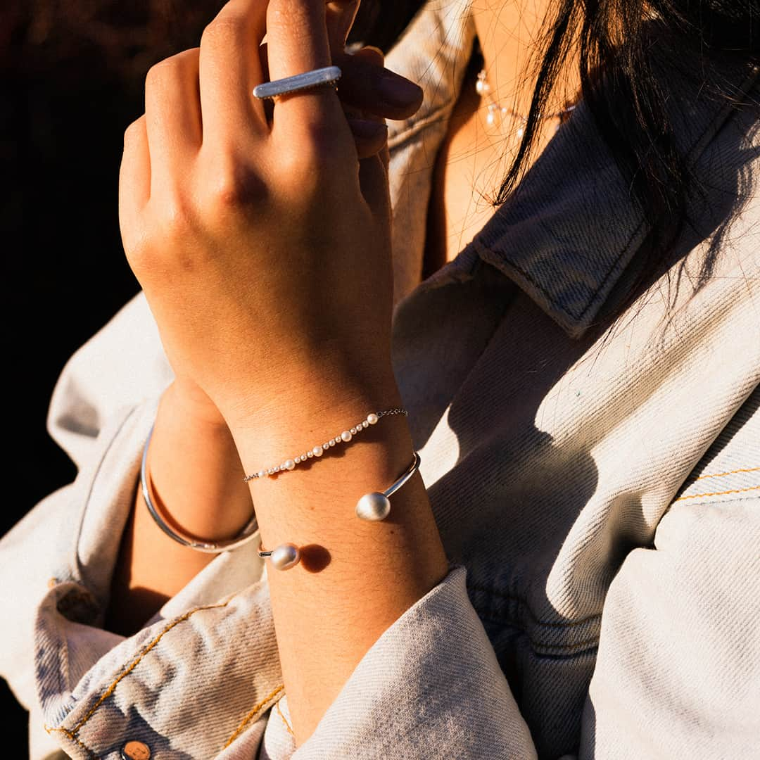 リンクスオブロンドンのインスタグラム：「Style up summer staples with light layers of jewellery. We've teamed the pearl & sterling silver Orbs bracelet with our grey pearl & sterling silver Hope open cuff bracelet and an engravable sterling silver Narrative ring. Tap to shop.  #LinksofLondon」