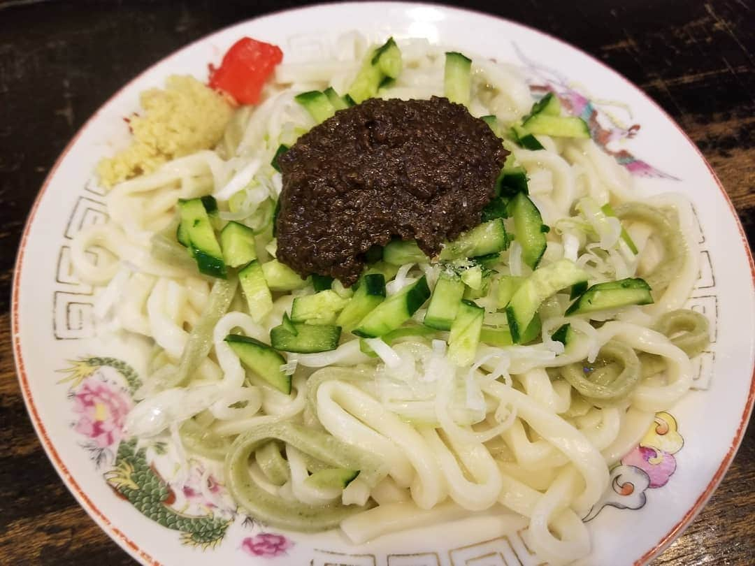 横山裕之のインスタグラム：「盛岡名物 「じゃじゃ麺」  白龍（パイロン）本店行きました。 「盛岡三大麺」の麺料理のひとつ。  特製の肉味噌とキュウリ、ネギ、そしてラー油やおろしショウガやニンニクや酢をかけて食べる。  麺を食べ終わった後の器に、卵を割り肉味噌を加え、茹で汁を注いでかき混ぜて食べる。 このスープを 「鶏蛋湯（チータンタン）」 最後までうまい。  PS 川田は  そこで  ハエにとまられてた。  #じゃじゃ麺 #盛岡 #パイロン #本店 #ちーたんたん #PS #川田 #ハエ #とまる」