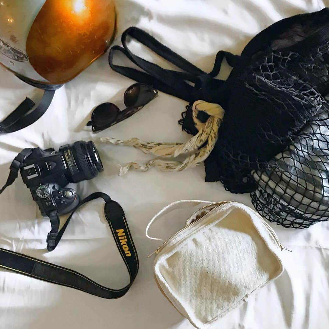 倉岡晋也のインスタグラム：「Preparing ✔︎ Scooter trip in Pai メッシュエコバッグの中に 突然のスコールに備えて雨カッパと タオル代わりの綿のストール どこの国にも連れていっているお気に入りの頒布のバッグに、小さなウォレットやらサングラスや蚊除けスプレーを入れて… 友達から譲り受けたNikonのカメラ あと、くねくねのバンダナは首に巻いたりカバンにつけたり この日も原付乗ってどこかに #倉岡旅の記録 #パーイ」
