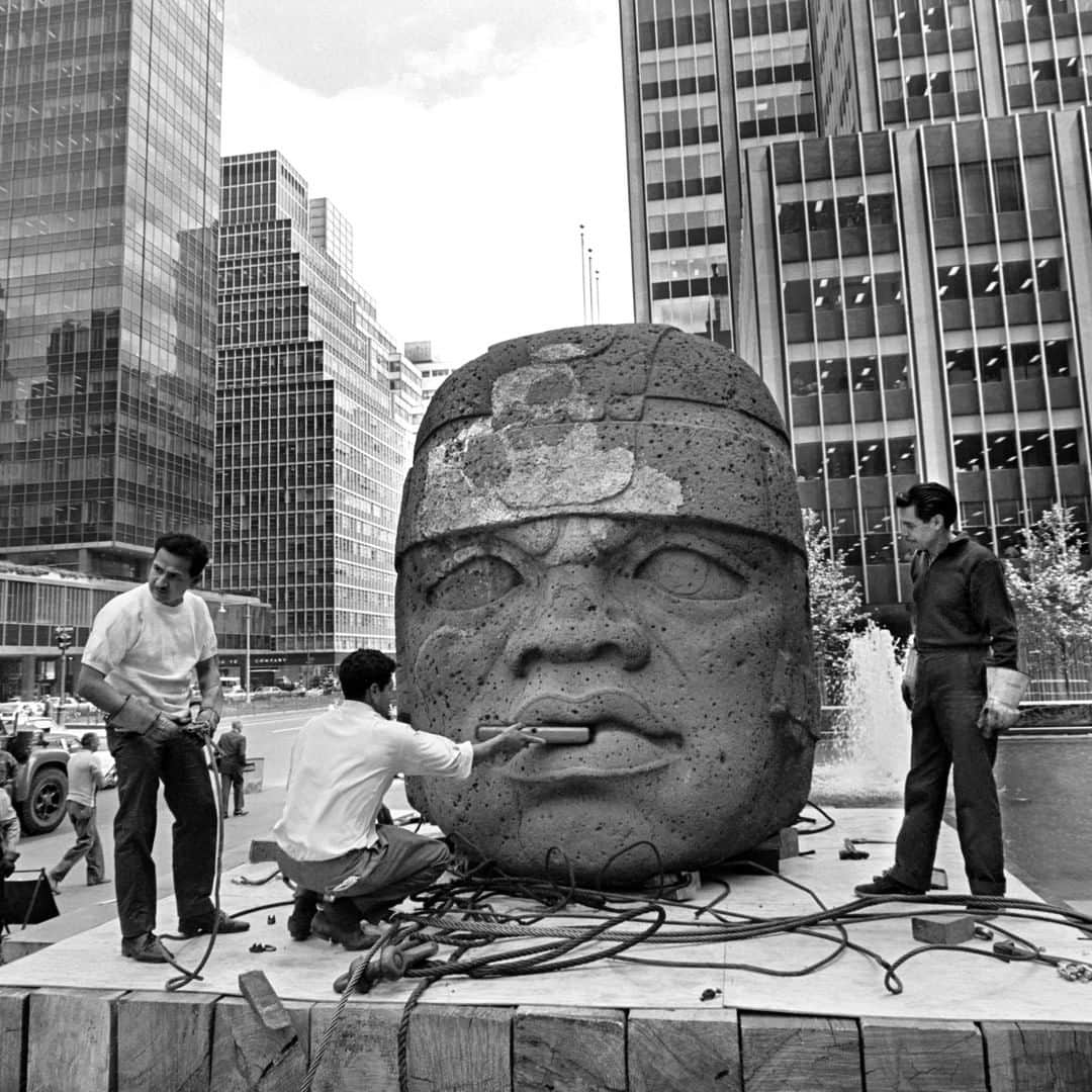 ニューヨーク・タイムズさんのインスタグラム写真 - (ニューヨーク・タイムズInstagram)「An ancient, 25-ton head carved out of basalt makes a pit stop at the Seagram Building, so the Park Avenue crowd can check it out for a month or two. One of a number of heads made by the Olmec people of Mesoamerica, the sculpture dates to sometime between 1200 and 900 B.C. It was lowered into this spot by crane in May 1965, and it made for a striking juxtaposition with the Seagram Building, a new, much-praised addition to the skyline with a sleek exterior of bronze and glass. The message seemed to be: This is where mankind has been; this is where it’s going. Visit the link in our bio for more examples of office building art, and follow @nytarchives for more photos from our archives. Photo by Eddie Hausner.」7月26日 6時20分 - nytimes