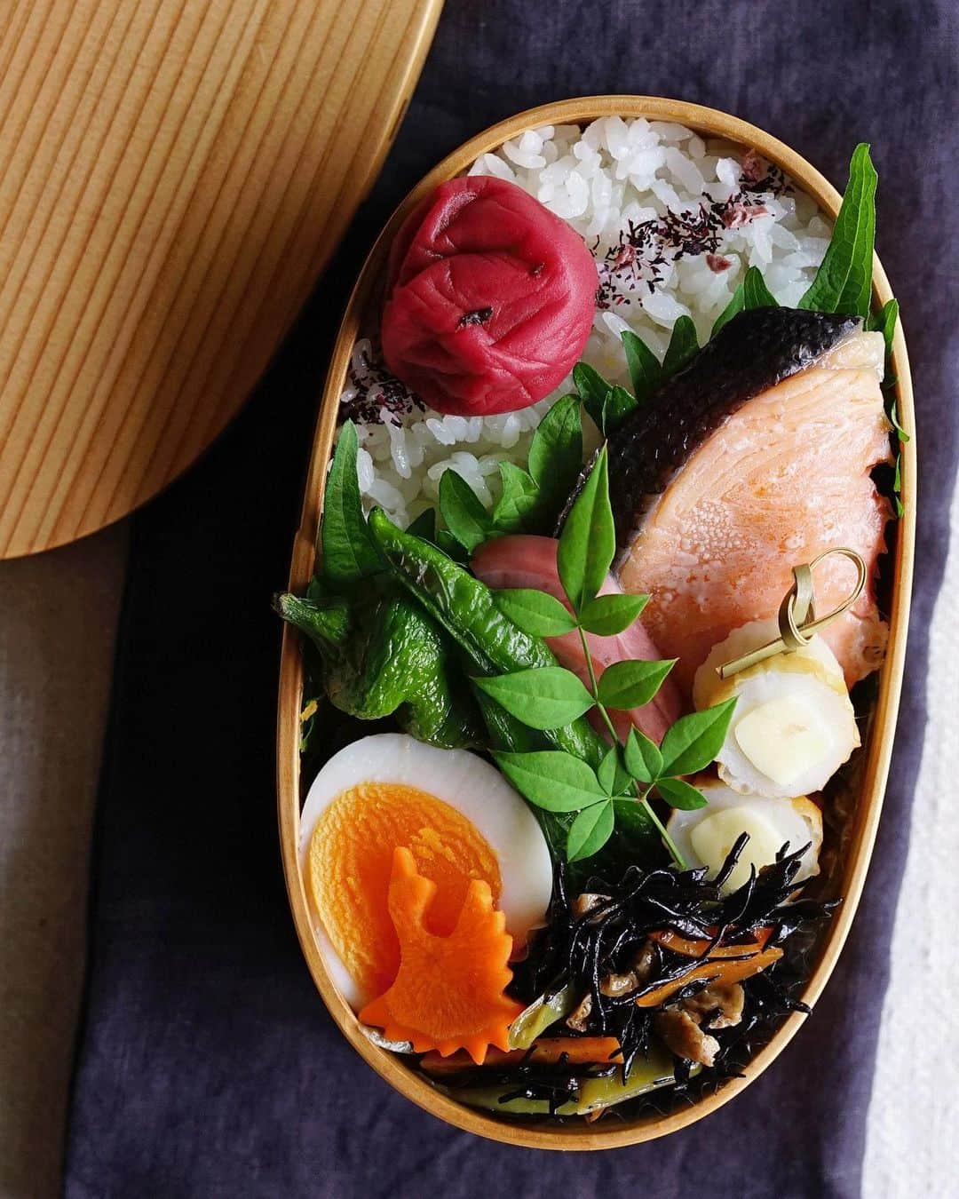 Ryoko Yunokiのインスタグラム：「+ + + Grilled salted salmon bento/焼き塩鮭弁当 . *rice and umeboshi *grilled salted salmon and green pepper *hard-boiled egg *hijiki salad *chikuwa and cheese *pickled red radish . ＊ご飯と梅干し ＊焼き塩鮭、万願寺唐辛子 ＊ゆで卵 ＊ひじきの煮物 ＊竹輪チーズ ＊赤蕪のお漬物 + + + #bento #お弁当 #丸の内弁当 #f52grams #曲げわっぱ #大館曲げわっぱ」