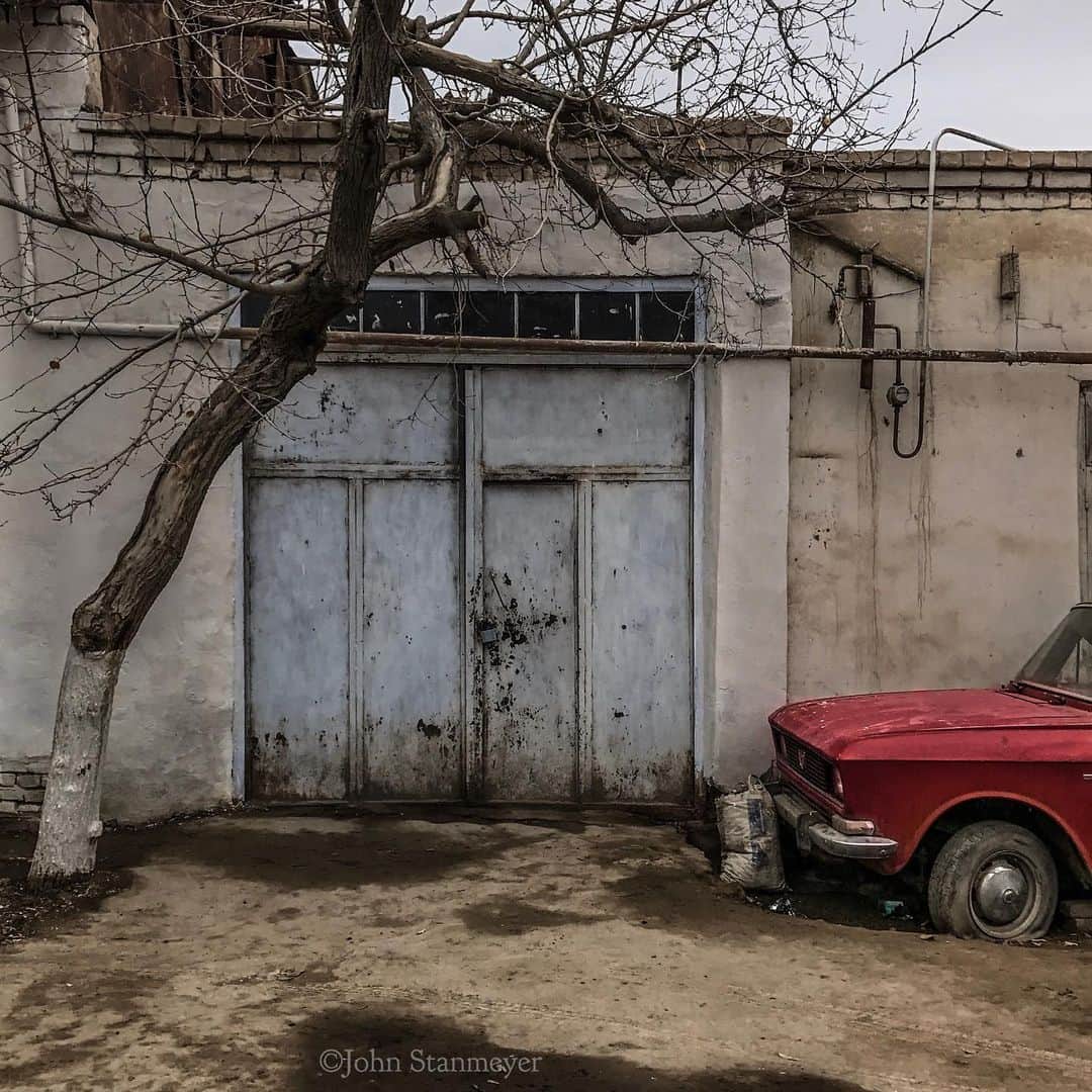 ジョン・スタンメイヤーさんのインスタグラム写真 - (ジョン・スタンメイヤーInstagram)「This street felt so familiar, like the place I am returning this weekend for the countless time I can no longer count. But it’s not Armenia. This photograph was in Khiva, Uzbekistan, a sister-stan to Ermenistan... The Soviet-era car, propane pipes, a tree that desires to exist in a setting of random placements. More from Armenia soon. So for now, a little bit more in similarities from another Stan, Uzbekistan. - #uzbekistan #khiva #soviet #russiancae #car @natgeo @natgeoimagecollection @outofedenwalk #tree #pipes @bridging.stories #bridgingstories2」7月31日 17時07分 - johnstanmeyer