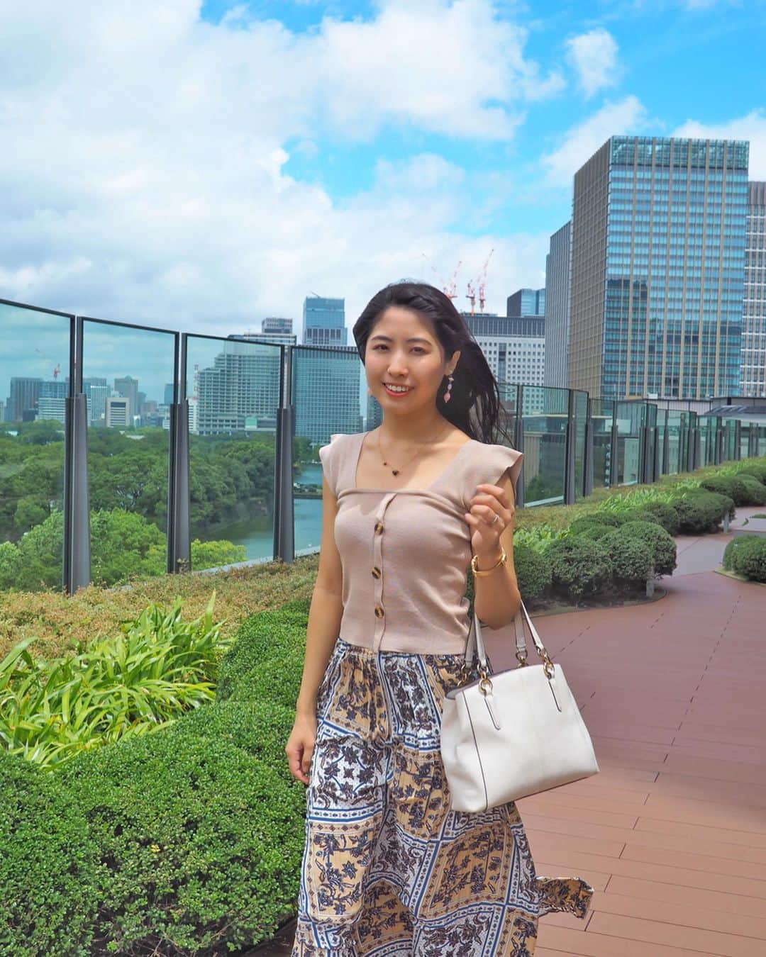 のインスタグラム：「おはよう🌈毎日カンカン照りが続くね～🌞﻿ 暑いからみなさん熱中症には﻿ くれぐれも気をつけてね🐶 ﻿ ﻿ 先週末は﻿ #東京ミッドタウン日比谷﻿ へ🚶‍♀️ ﻿ ﻿ #空中庭園﻿ がすごく気持ちよかった～☁ ☁ ☁ ☁ ☁ ☁﻿ ﻿ (この日は強風で、あおられる笑 風の音が動画にすごい入ってる)﻿ ﻿ ﻿ 日比谷公園と、皇居が見渡せる✨﻿ ﻿ ﻿ 都会の真ん中にいながらも﻿ この落ち着き🌳﻿ 品のある雰囲気﻿ すきだーーー🥰﻿ ﻿ ﻿ ﻿ ﻿ ﻿ よく東京のオススメスポットを﻿ 聞かれるんだけど、﻿ ミッドタウン日比谷は 間違いないな🥰﻿ ﻿ ﻿ ﻿ ﻿ #日比谷#有楽町#東京﻿ #おでかけスポット #おでかけ#休日の過ごし方 #休日コーデ #coordinate #コーデ#fashion#ootd#ノースリーブニット #ノースリーブ#ベージュコーデ #プリーツスカート  #coach #ファッション#おしゃれ#おしゃれさんと繋がりたい #東京観光 #japanesegirl #japan#instalove ﻿ #ゴジラ ﻿ #こやゆりコーデ」