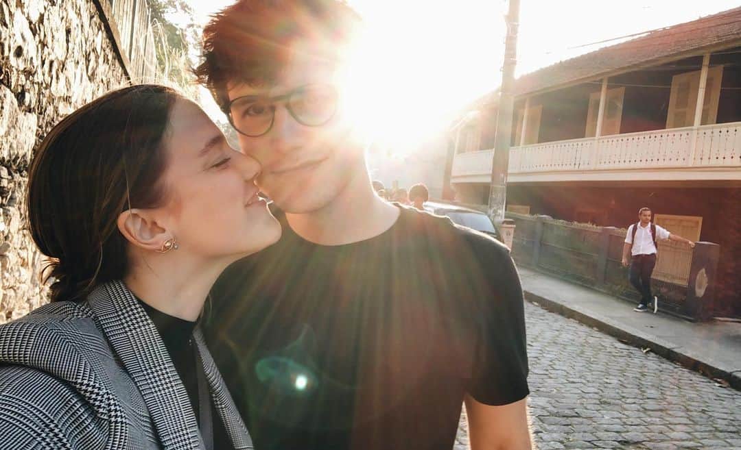 Alice Wegmannのインスタグラム：「era sexta feira da semana passada, cheguei pra jantar com Miguel no restaurante todo cheio, depois de 26 cenas gravadas num dia bastante longo. ele me deu um beijo e elogiou minha roupa toda branca. eu tava exausta. ele disse que eu tava linda. tinha feito algumas cenas de emoção aquele dia e por algum motivo que ainda não descobri qual, não conseguia fechar a torneirinha. ia cortando o peixe derramando lágrimas e rindo e chorando mais. ele me estendia a mão entre uma garfada e outra e dizia como achava bonito ser artista. e depois me deu cafuné e massagem e tivemos esse fim de semana da foto. estamos apegados aos domingos, que é quando a gente finalmente encontra um tempinho mais nosso, de se jogar no sofá da sala, comer chocolate e fazer nada juntos. já passaram 6 meses desde o dia em que a gente se pediu em namoro, parece que faz muito mais, ao mesmo tempo parece que foi ontem, eu perco completamente a noção do tempo quando encontro esses olhos de girassol. hoje eu tô em são paulo e ele no rio mas pouco importa a distância porque a vontade é de estar bem pertinho. eu te amo meu amor, e logo chego pra te dar mais beijos. @miguelribasgastal」