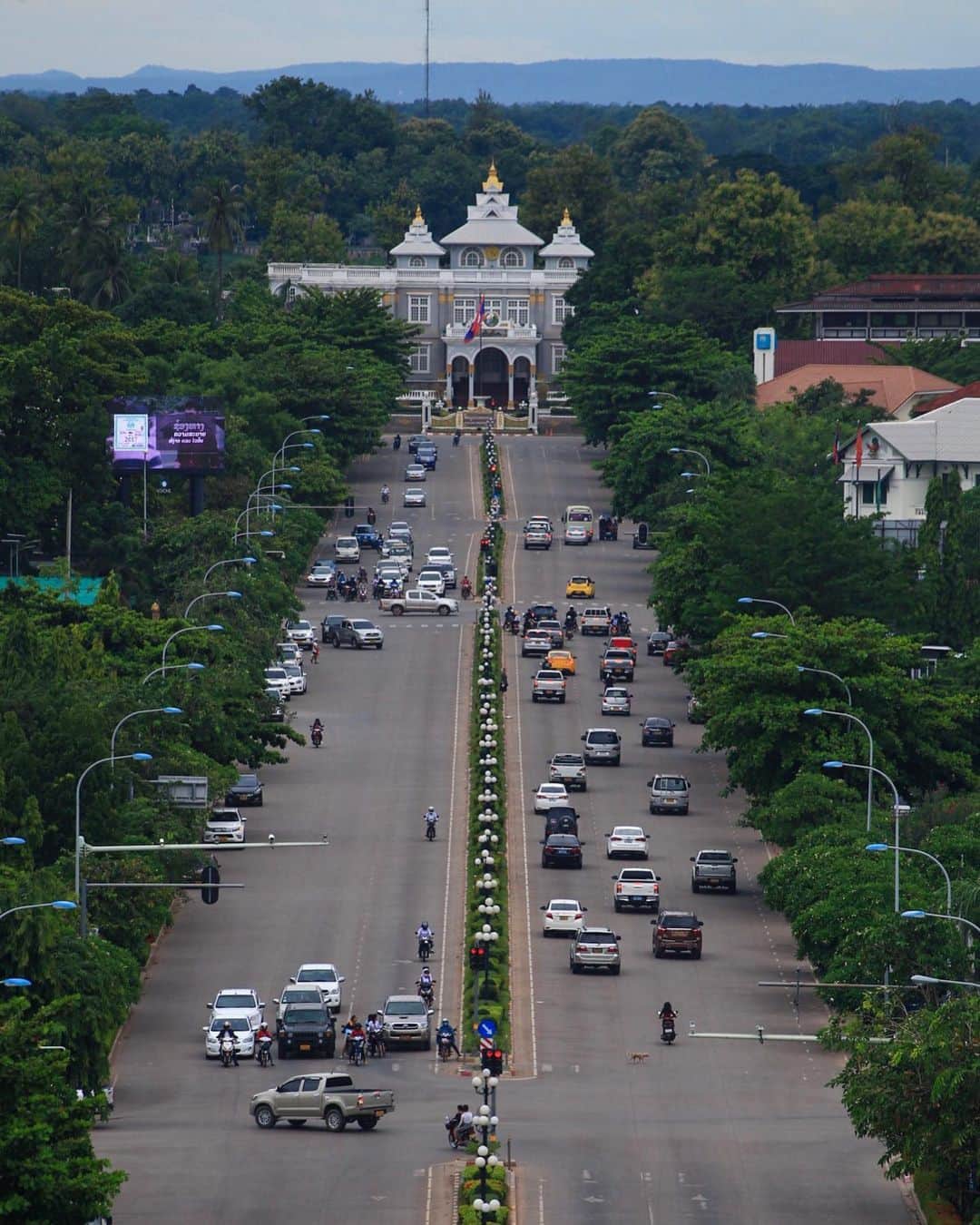 Shunsuke Miyatakeのインスタグラム：「Presidential Palace of Laos. / ラオス大統領府  When I was taking photos in Vientiane in the rain, I was standing on a roadside and talked with an 50 years old man from Leipzig. “Why do you take this scenery? This country is too poor for me” he said. I said “Collecting everyday life not decorated”. He said, “There is nothing here”  I said “that would be nice” He said “Japan would be better” I said “Germany is also wonderful, isn't it?” He said “now there are too many poor immigrants and it has changed. Immigrants should not be accepted. Does Japan not accept immigration?” I said “The economy would stuck if we don't accept them, and if I say it in detail, children's poverty is among the top class in the G7” He said “I did not know! See you!” Now I got complicated.  Hearing the thoughts of others who are different from myself and shaking my initial stance will lead to the acquisition of new perspectives. Viva! Stranger!! /  雨のヴィエンチャンで写真撮ってるときに道端でばったり出くわしたライプツィヒ出身のおっさんと立ち話してたんだけど、この風景を何故撮るのか？と。飾らない日常を集めてんだっつったら、この国は貧しすぎて俺には無理だと。何も無いと。おれはそこが良いと思うんだっつったら日本の方が良いだろうと。ドイツも素敵だろ？って聞いたら昔と変わって今は貧しい移民が多すぎて変わっちまったと。移民は受け入れてる場合じゃないと。日本は移民を受け入れないだろ？と。いや細けえ事言ったら受け入れないと経済が回らなくなってるし子供の貧困はG7の中でもトップクラスだよと。知らなかった！またな！って立ち話でいま複雑な心境。まあ。自分とは異なる他人の考えを聞き、最初に持ってたスタンスが揺らげばこそ、新しいパースペクティブを獲得することに繋がると。Viva! Stranger!!」