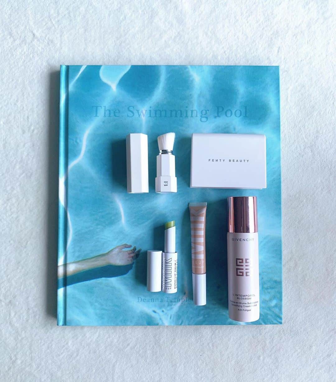 佐川理佳のインスタグラム：「s u m m e r 🏄🏼‍♀️ m a k e u p @givenchybeauty  L'INTEMPOREL BLOSSOM  cream in mist クリームがミスト状になっているので、メイク直しにとても便利。微粒子でフワっと出てくるのが気持ち良い。飛行機など長時間の移動が多いときもおすすめなので旅行にぜひ。  @milkmakeup KUSH LIP BALM milkのリップバームはセラムタイプも愛用していますが保湿力が高く、長時間持続するのでお気に入り。これはgreen dragonというカラーですが、塗るとほぼクリアです。ミントの香り。  FLEX CONCEALER 汗でメイクが崩れたら、クリームミストでヨレをなじませたあと、このコンシーラーを少量つけて気になるところをカバー。 ファンデーションのように柔らかいテクスチャーなので、ナチュラルに仕上がります。  @fentybeauty  INVISIMATTE  Blotting Powder Tゾーンのテカリが気になるときに。 このパウダーはちゃんとサラサラマットになるけど、重たく見えないのでお気に入りです。そして毛穴を目立たなくしてくれる&透明感を出してくれるので、バッグが小さい日でもいつも持ち歩いてます。」