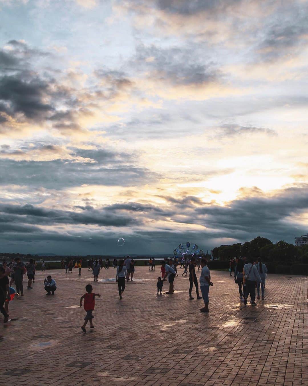 Shunsuke Miyatakeのインスタグラム：「Dusk after the rain / 雨上がりの夕暮れ。  Unusually, I was asked by a group of students to have a short conversation at Riverside, where people spend their time. They said they wanted to talk a little because they wanted to practice English and learn foreign culture. They talked passionately with a young, fresh eyes so I agreed. New to Laos? What food did you eat in Laos? Where is your favorite place in Laos? Which part of Japan are you coming from? What kind of place is Yokohama? Where is your favorite place in Japan? May we take photo with you at the end?  After asking what they wanted to hear from me, they went to look for the next foreigner. Catching foreigners on the street and listening in English what they want to hear. It was kind of nostalgic and overlapped with myself. I was inspired by the experience in Exeter, the city near from London, UK, which I first went when I was 15. I wanted to go around the world and to be connected with people all over the world.  The experience has led me to work that brings me to Laos now.  There was a very nice passage at the beginning of Lobsterr, a favorite e-mail magazine that just arrived this morning. "It's easy to become "I know" with a few swipes on your smartphone. Just because we live in such an era, it's so important for us to stand still a little bit, and to get in touch with our surroundings, especially with the people around us, with a stance "I don't know better than I think". It would be a big first thing to the world you haven't yet seen." 雨上がりの夕暮れ。ヴィエンチャン。  人々が思い思いの時間を過ごすリバーサイドで、珍しく学生のグループから声を掛けられた。曰く英語の練習と海外の文化について知りたいから少し会話をさせて欲しいとのこと。若く瑞々しい視線を向けて熱っぽく話しかけられたので快諾した。ラオスに来るのは初めてですか？ラオスのどんな料理を食べましたか？ラオスの好きなところはどこですか？日本のどこから来ましたか？横浜はどんなところですか？日本の好きなところはどこですか？最後に写真を一緒に撮らせてもらってもいいですか？  聞きたいことを聞いて彼らは次の外国人を探しに行った。道端で外国人らしき人間を捕まえて、自分たちが聞きたいことを英語で聞いていく。なんだか懐かしかった。15歳のときに初めて行ったイギリスのエクセターという街に刺激を受けて、とにかく世界中の人たちと繋がりたい、世界中を見て回りたいと思った頃の自分と重なったからだ。その経験があったからこそいまラオスに来るような仕事に繋がってる。  今朝届いたばかりのお気に入りのメールマガジン、Lobsterrの冒頭にとてもしっくりとくる一節があった。 “スマートフォンの数スワイプで「知っているつもり」になるのは簡単だ。そんな時代を生きているからこそ、少しだけ立ち止まり「自分は自分が思っているよりよっぽど知らない」というスタンスで身の回りの環境、とりわけ周囲の人々と関わることが、まだ見ぬ世界への大きな第一歩になるだろう。”」