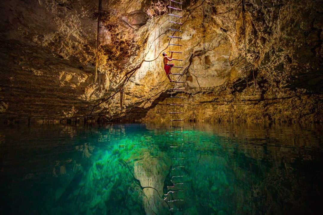 National Geographic Travelさんのインスタグラム写真 - (National Geographic TravelInstagram)「Photo by @paulnicklen | Unseen in a cenote near Tulum: a few feet below the surface of the water lie the remnants of an ancient culture and clues to ritual hidden in time. Over a hundred Mayan people were found buried in Las Calaveras ("the skulls"); archaeologists examine their skulls and bones to discover the secrets of their deaths, and gain a better understanding of how they came to be there. I have never been so aware of every inch of my body, camera and fins while hovering just inches above this incredibly delicate and important site. For the Maya, both caves and cenotes were considered mouths that opened into another world. Today, this is a popular destination for cooling off after a long hike through the rainforest, nearby the pyramid at Cobá. In this photo, local guide Angel Canul ascends a rope ladder after checking to make sure every tourist has safely left the cenote. To see more images from this underwater graveyard, please #followme at @PaulNicklen. #explore #mexico #culture #respect」8月5日 22時02分 - natgeotravel