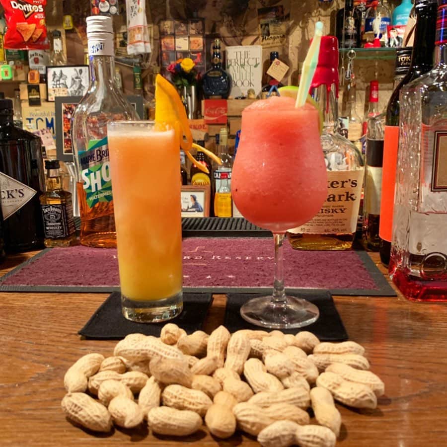 紀伊さつきのインスタグラム：「「美味しいお酒が飲めますよ」と、とくだマスターが呼んでくださったので、 先日ういよ様にとくだ様のバーへ連れてっていただきました。 バーとか人生で数えるくらいしか行ったことないから楽しかった…！ 先輩の普段と違う一面も見られて、シェイカーしゃかしゃかすごー！！とテンションUP。 思わずムービーもまわしましたが(オシャレに振る舞えない女)、しっかり「アホちゃう？」とええ声で突っ込まれてるのも入ってました(笑) ・ オーダーはすべて、マスターにおまかせ😊✨ 私が作ってもらったのは右側で、 1杯目#シーサイドストーリー (#スイカのカクテル ) 2杯目#モヒート ういよさんのが左側で、 1杯目#ういよザサンセット 2杯目#ういよザハリケーン ・ ういよさんレベルになると、オーダーしたドリンクにご自身の名前が付きます。なんてこったすごい…！(笑) ・ 殻付きのナッツは剥いたら殻を床に捨てていくワイルドスタイル。 床に殻なんて落としたら叱られる！みたいな心理が染み付いてるので、はじめは床に捨てるときはういよさんと「せーの！」の掛け声で捨ててました(オシャレさ台無しアゲイン)。 でも帰る頃にはせーのなしでポイ！できるくらいワイルドレディに成長できましたよ💪✨(笑) 踏むとサクサクいうのが楽しい！ とくださん、ういよさん、素敵な夜をありがとうございました☺️💓 ・ #bar #cocktail #オシャレな夜  #マスターがお客さんにモテモテ」