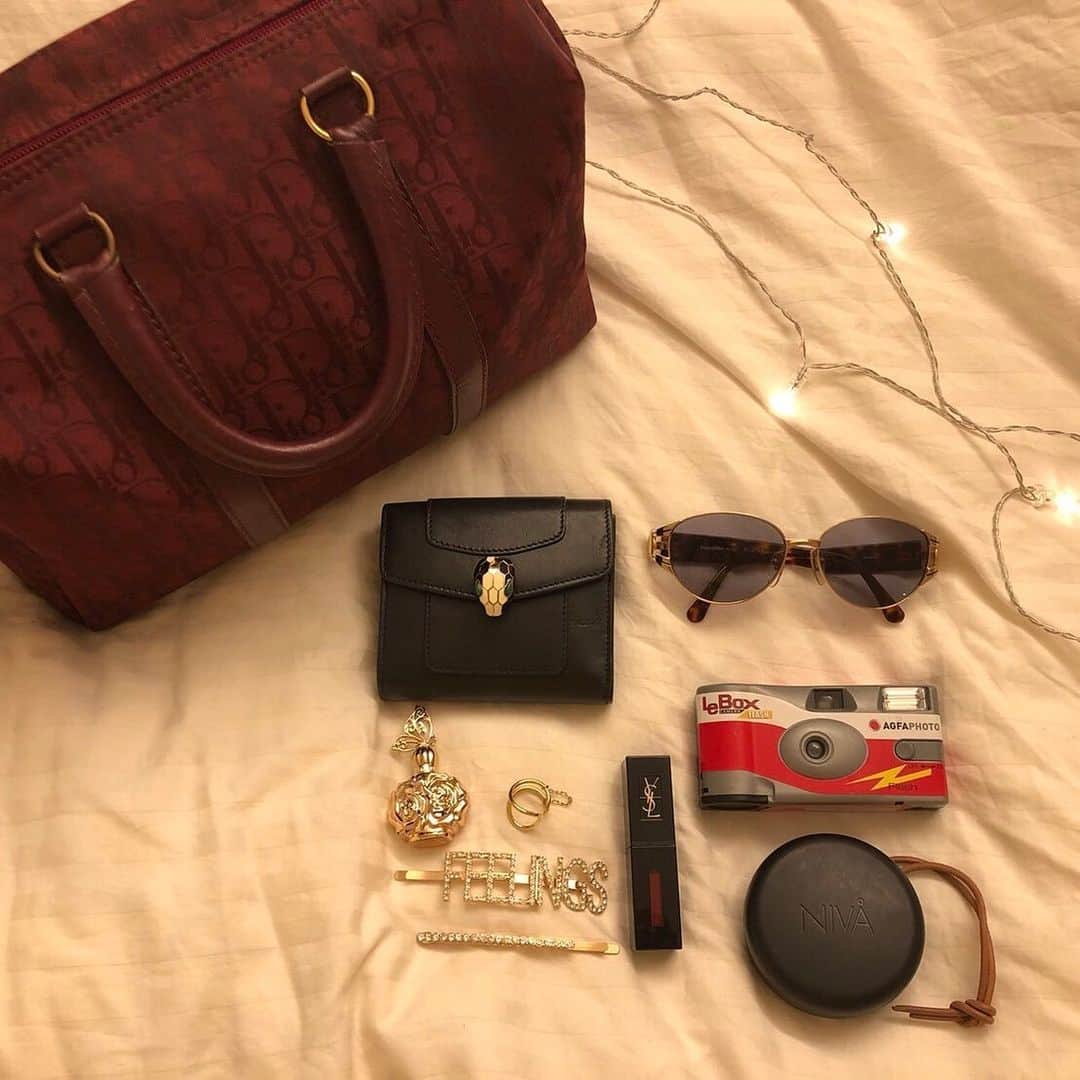 ELLE girl JAPANさんのインスタグラム写真 - (ELLE girl JAPANInstagram)「What's in my bag？👜﻿ ﻿ いつもおしゃれなELLEgirl UNI creatorたちのカバンには何が入っているの？👜お財布やコスメから意外なものまで？！👀UNI creatorのカバンの中身を拝見💘﻿ ﻿ 💁🏻‍♀️RINA( @rinahagai )﻿ ﻿ 🤔バッグについて教えて！﻿ お誕生日プレゼントに貰ったヴィンテージの「 #ディオール 」のbagを愛用中♡ボストン型のシルエットと、'80sっぽいロゴ入りデザインがお気に入り！﻿ ﻿ 🤔バッグ選びのポイントやこだわり﻿ 荷物はコンパクトにまとめたい派なので、財布とリップだけが入るような小さめバッグが好き💼﻿ ﻿ 🤔バッグの中身を教えて！﻿ ・お財布／ #ブルガリ ( @bulgariofficial )﻿ ・サングラス／ #イヴサンローラン ( @ysl )﻿ ・リップ／ #イヴサンローラン ( @yslbeauty )﻿ ・ イヤフォン／ #スーディオ ( @sudio )﻿ ・香水／ #アナスイ( @annasui_japan )﻿ ・指輪／ #ユーカリプト( @ucalypt_accessories )﻿ ・ヘアピン／ #ギャレリートーキョー( @gallerie_tokyo )﻿ ・フィルムカメラ( #lebox )／ #agfaphoto (👈友達と遊ぶ時、フィルムカメラで写真を撮り合うのにハマってるよ📸)﻿ ﻿ #ellegirluni #ellegirl #whatsinmybag #diorbag #bulgari #ysl #ysleyewear #ysllipstick #sudio #yslリップ #サングラス #フィルムカメラ #ucalypt #annasui香水 #annasui #gallerietokyo #ヘアピン #カバンの中身」9月2日 21時00分 - ellegirl_jp