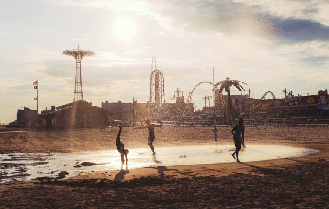 National Geographic Travelさんのインスタグラム写真 - (National Geographic TravelInstagram)「Photo by @MichaelGeorge | Coney Island is a joyful heart of New York City. The sun, salt, and spray mix in the air with the sound of screaming from all the local attractions. In this image, kids play in a water feature along the beach. Luna Park and the Wonder Wheel are open until October, so you’ve still got time to escape the city and have a wonderful beachside escape. My recommendation is to get there in the afternoon, and then watch the sunset from the boardwalk! #coneyisland #lunapark #boardwalk #brooklyn #nyc」9月4日 9時04分 - natgeotravel