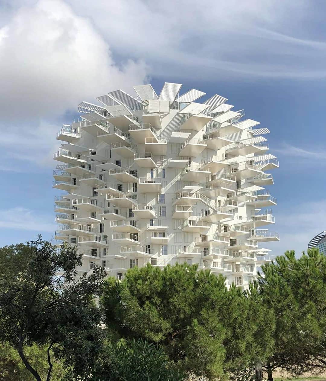 のインスタグラム：「We love the new L’Arbre Blanc, a 17-storey ‘tree’ of apartments that rises from the banks of Montpellier, boasting an array of balconies and mini parasols, which sprout out from its core. Architects: @sou_fujimoto, @oxo_manalrachdi and @nicolaslaisnearchitectes. 📷 by @wallpapermag  #OBsAroundTheWorld #JamesBond #OrlebarBrown」