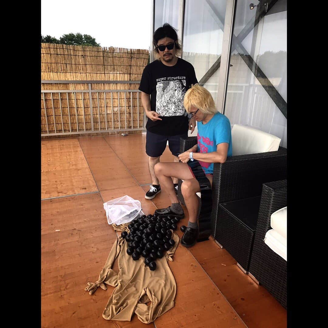 マキシマム ザ ホルモンさんのインスタグラム写真 - (マキシマム ザ ホルモンInstagram)「【事件だッ!!】ウ!!! "ROCK IN JAPAN FESTIVAL 2019"の出番目前にアーティストエリアで、何者かが俺を狙って放った吹き矢が刺さって……ウ!!! 動けない……。 偶然、通りかかったウルフルズの皆さんが発見してくれて、「ガッツだせ！！ガッツだせ！！」と、パワフル魂を注入してくれてます。 (これによく似た場面を『ガッツだせ！！』のMVで見たことあるような気が……) ち、ちくしょう……GRASS STAGEで、なにはなくとも、DO the ド根性で、汗かいてベソかいてGO!したいのに……。 サムライソウルを持つバカサバイバーとして、がむしゃらに熱くなれれば、とにかく笑えれば、それでええねん。それが答えだ！  byダイスケはん娘。'19(←ただ使ってみたかっただけ娘。'19)  #マキシマムザホルモン #RIJF2019 #ウルフルズ #アーティストエリアの端っこで工作してる人がいたからグッドモーニングって挨拶してきた #グッドモーニングアメリカ #何が出来上がったかは彼らの本番でベースのタナシンの登場で答え合わせして下さい」8月11日 16時08分 - mth_official_33cjl