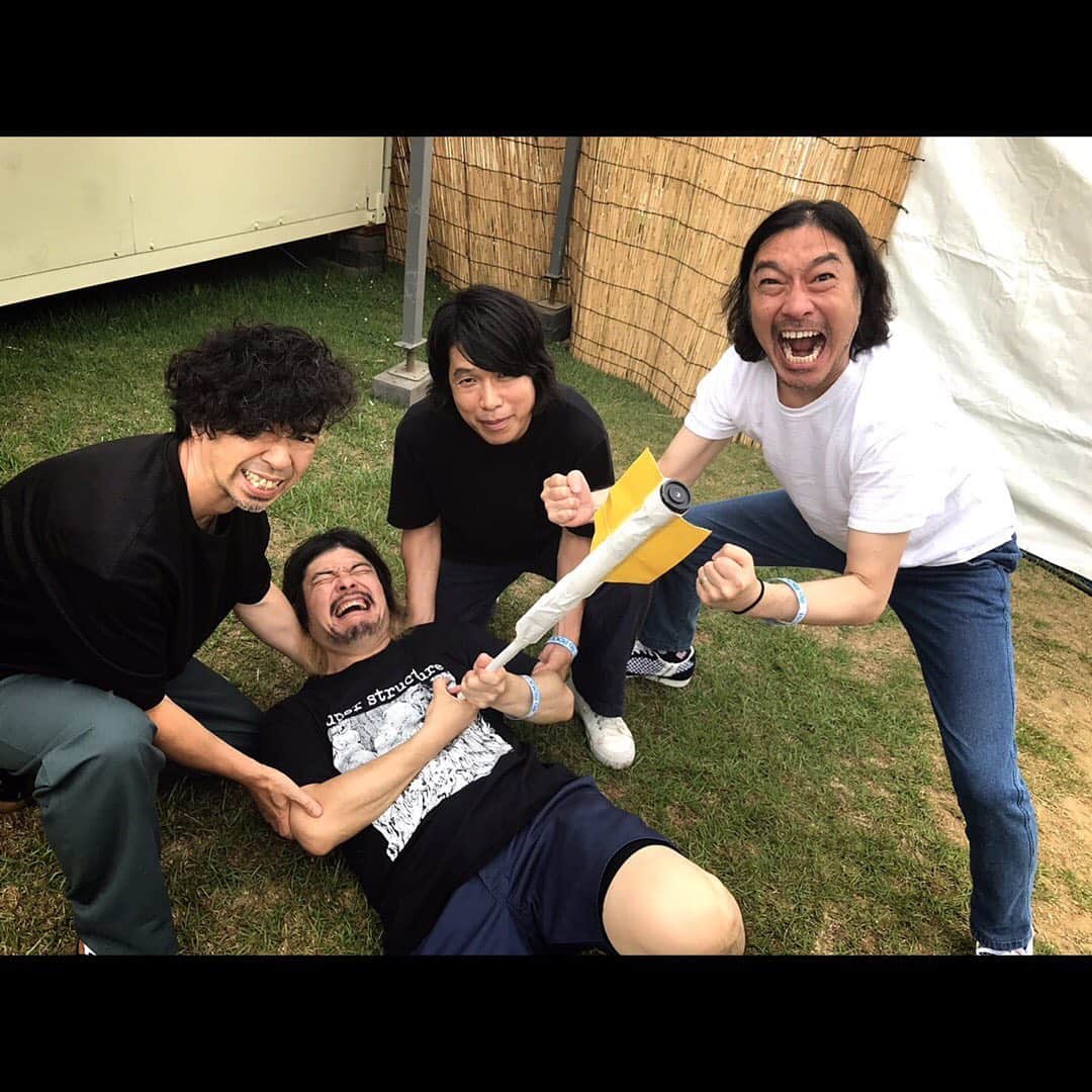 マキシマム ザ ホルモンのインスタグラム：「【事件だッ!!】ウ!!! "ROCK IN JAPAN FESTIVAL 2019"の出番目前にアーティストエリアで、何者かが俺を狙って放った吹き矢が刺さって……ウ!!! 動けない……。 偶然、通りかかったウルフルズの皆さんが発見してくれて、「ガッツだせ！！ガッツだせ！！」と、パワフル魂を注入してくれてます。 (これによく似た場面を『ガッツだせ！！』のMVで見たことあるような気が……) ち、ちくしょう……GRASS STAGEで、なにはなくとも、DO the ド根性で、汗かいてベソかいてGO!したいのに……。 サムライソウルを持つバカサバイバーとして、がむしゃらに熱くなれれば、とにかく笑えれば、それでええねん。それが答えだ！  byダイスケはん娘。'19(←ただ使ってみたかっただけ娘。'19)  #マキシマムザホルモン #RIJF2019 #ウルフルズ #アーティストエリアの端っこで工作してる人がいたからグッドモーニングって挨拶してきた #グッドモーニングアメリカ #何が出来上がったかは彼らの本番でベースのタナシンの登場で答え合わせして下さい」