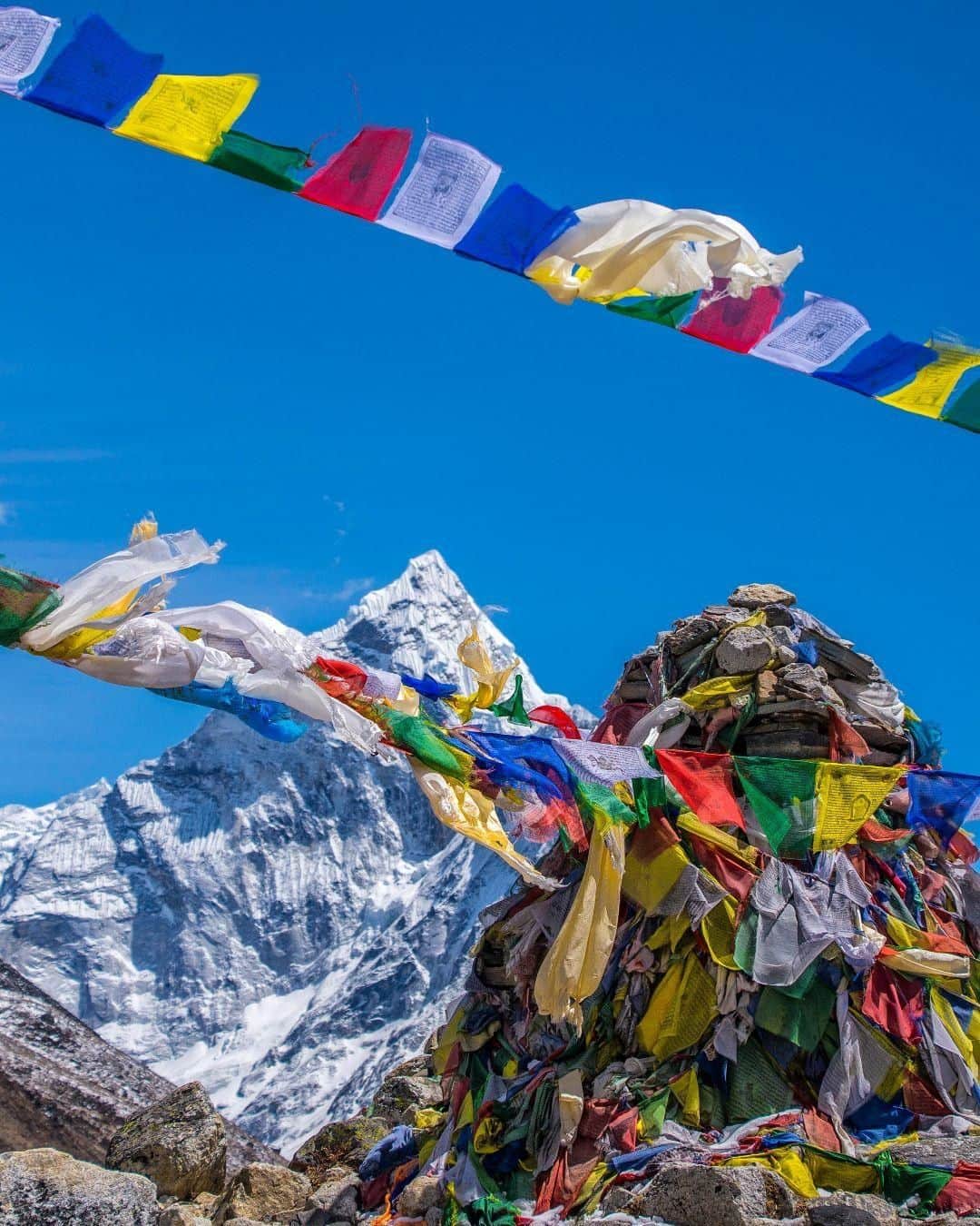 Lonely Planetさんのインスタグラム写真 - (Lonely PlanetInstagram)「'Prayer flags flap in the wind at the #Everest memorial at Chukpi Lhara near the village of #Pheriche. Dotted with stone piles and plaques with prayer flags strung between them, the memorial is dedicated to the hundreds of sherpas and climbers who have died on the mountain over the years. Despite its stunning location, the memorial is a sobering reminder of the dangers that accompany high-altitude climbing and #trekking.' – @atlasandboots #Nepal -- Tap our link in bio for more info on trekking Everest responsibly.」8月11日 19時00分 - lonelyplanet