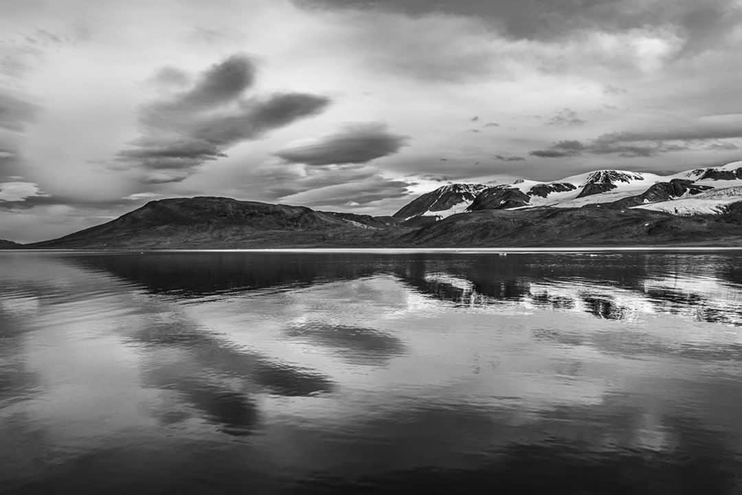 National Geographic Travelさんのインスタグラム写真 - (National Geographic TravelInstagram)「Photo by @daisygilardini | The Norwegian archipelago of Svalbard lies midway between Norway and the North Pole, between 74°81N and 10°35E.  Some locations are monochromatic by nature, and Svalbard is one of them. I love the symmetry of the mountain perfectly reflected in the sea. Follow me @DaisyGilardini for more images and stories behind the scene #landscapephotography #reflection #svalbard #Norway」8月13日 7時06分 - natgeotravel