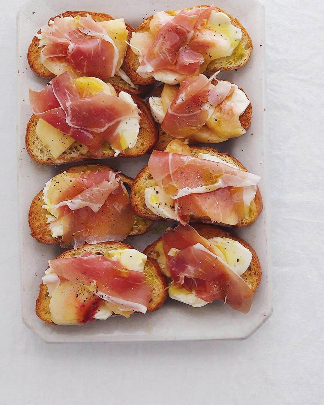 樋口正樹さんのインスタグラム写真 - (樋口正樹Instagram)「Peach, Prosciutto & Mozzarella Bruschetta . 今朝はフォカッチャに モモとモッツァレラと 生ハムを組み合わせた おいしいブルスケッタ。 朝食ですけど、本来は おつまみメニューです。 . . パンはタカキベーカリーの石窯オリーブオイルフォカッチャを薄く切ってトーストし、ニンニクを軽くすりこみ、モモとモッツァレラと生ハムを重ねて、胡椒とオリーブオイルを回しかけるだけの簡単メニュー。ちなみに桃とモッツァレラは常温で使うのが断然に美味しく、風味がグンっと強く感じられます。この組み合わせはおつまみとして最高で、微発泡の辛口白ワインと合わせるのがおすすめ。 👉@takaki_bakery_official . . #桃モッツァレラ #パルマハム #ブルスケッタ #フォカッチャ #タカキベーカリー #石窯オリーブオイルフォカッチャ #石窯パン #パン部 #朝ごはん #朝ごパン #パンスタグラム #パン大好き #朝食はしっかり食べよう推進委員会 #お手軽料理 #簡単朝食 #朝の楽しみ #Focaccia #topitalianfood #prosciuttodiparma #mozzarella #bruschetta」8月15日 7時19分 - higuccini