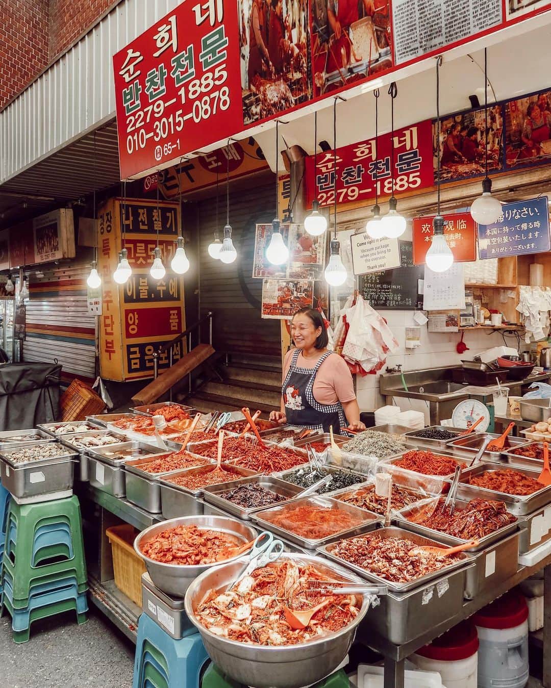 W E Y L I Eのインスタグラム：「...and the Korea photos continue 😂 I had to share this post because I had the best time at the Gwangjang Market. It’s a market located in Seoul- you will find traditional Korean street food, side dishes, clothing, and home goods. We decided to stop by the market after watching an episode of Street Food (Netflix show) that highlighted some of the stalls here. Every stall owner was extremely friendly and majority of them are run by boss ass women!! These ladies are cooking under hot & humid weather but still manage to smile at every tourist or local that walked by. This woman especially stole my heart because she smiled at every single person that walked by. She saw Wah and I holding a camera and was so inviting and happy to be photographed. While we were waiting in line, she handed us yogurt drinks because she saw that we were breaking out in sweat. If you happen to visit the market, definitely check out her shop! She is right off of the center of the market!」