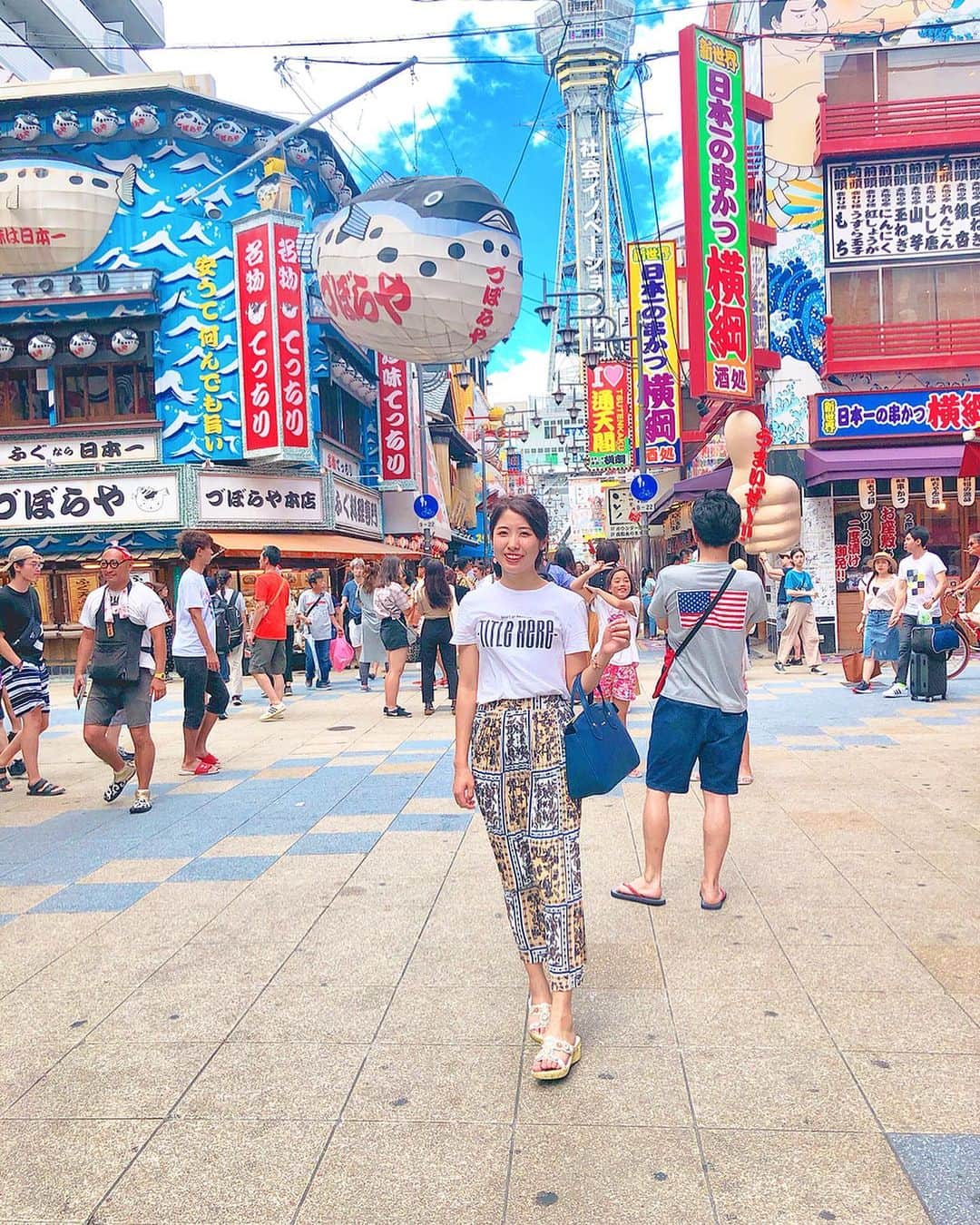 のインスタグラム：「大阪の街をぶらり～🙌💕﻿ #新世界 に行ってきたよ！(昨日ね♪)﻿ 通天閣の高さ108m♪﻿ 街も通天閣も文字がいっぱい！﻿ カラフルで看板の主張が凄い🤣🧡(笑) ﻿ この大阪ならではの賑やかな雰囲気いいね﻿ (*´ο`*)🐙﻿ ﻿ ﻿ ﻿ #大阪#大阪旅行 #大阪観光 #通天閣#こやゆり旅 #ootd#旅#旅コーデ#ビリケン#串カツ#japanesegirl #osaka #travel」
