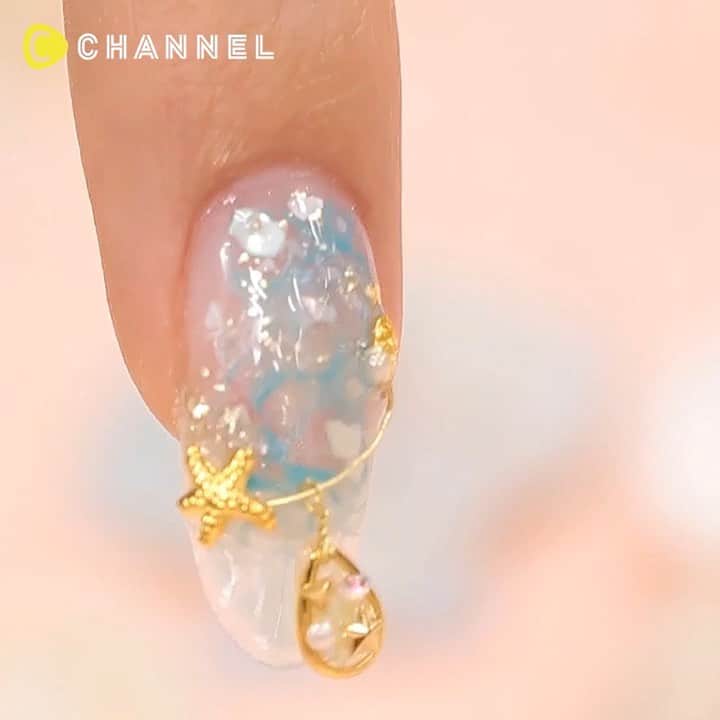 のインスタグラム：「🌟ゆらゆらチャームがかわいい♡きらきらマリンネイル🏖 . 💗Check👉 @cchannel_girls 🎶 💗Follow me👉 @cchannel_beauty 🎵 . 💄C CHANNELのアプリもよろしくお願いします😊💕 . ワイヤーにきらきらチャームを通した、揺れるマリンネイル♪  人魚姫のようなゴージャスネイルにうっとり♡ . 【💅手順】 １、クリアジェルをベースにしく  ２、濃いブルー、水色、乳白色のジェルをランダムにのせる  ３、硬化させる前に上からクリアジェルをのせ、色を混ぜ伸ばしていく  ４、シェルをのせる  ５、ホイルでキラキラをつける  ６、クリアジェルを厚めに塗る  ７、土台を剥がす  ８、拭き取って、爪の形を整える  ９、トップジェルをぬる  １０、パーツを通す  １１、金箔をのせる １２、コーティングして完成 . produced by cin-cia nail academy @cincia_nail http://cin-cia.com/ . . #マリンネイル#サマーネイル#夏ネイル2019#夏ネイルデザイン#立体ネイル#3dネイル#ゆらゆら#ワイヤーネイル#大人可愛いネイル#爽やかネイル#ネイルアートデザイン#ジェルネイルデザイン#個性派ネイル#個性的ネイル#水色ネイル#手元くら部#ぷっくりネイル#ネイルチェンジ#ネイルスタグラム#ネイルカタログ#リゾートネイル#クリアネイル#透け感ネイル#シースルーネイル#キラキラネイル#海のある生活#ワンポイントネイル#ネイル動画#ネイル好き」